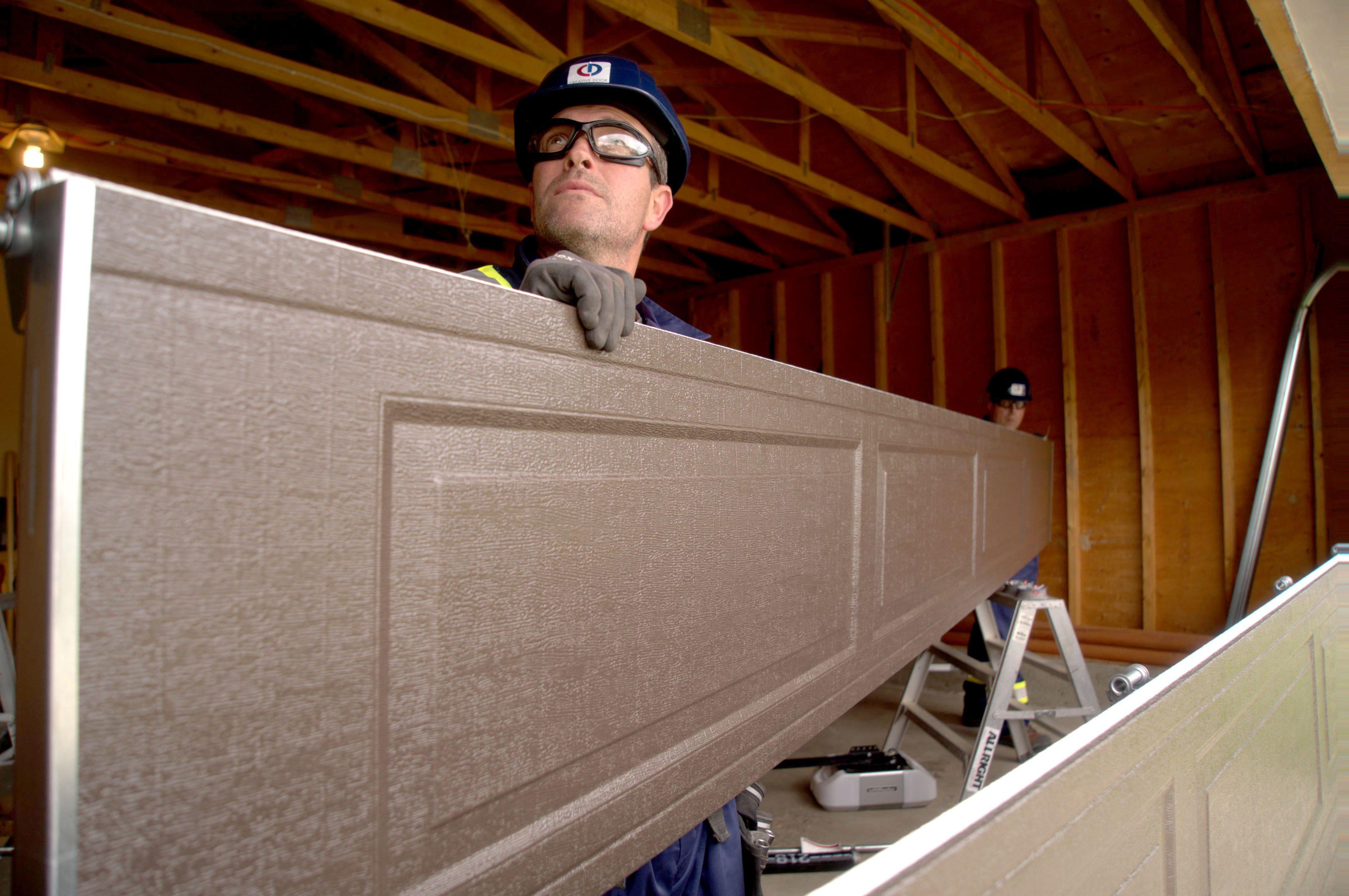 creative door service technician installing a new garage door creative door service technician installing a new garage door