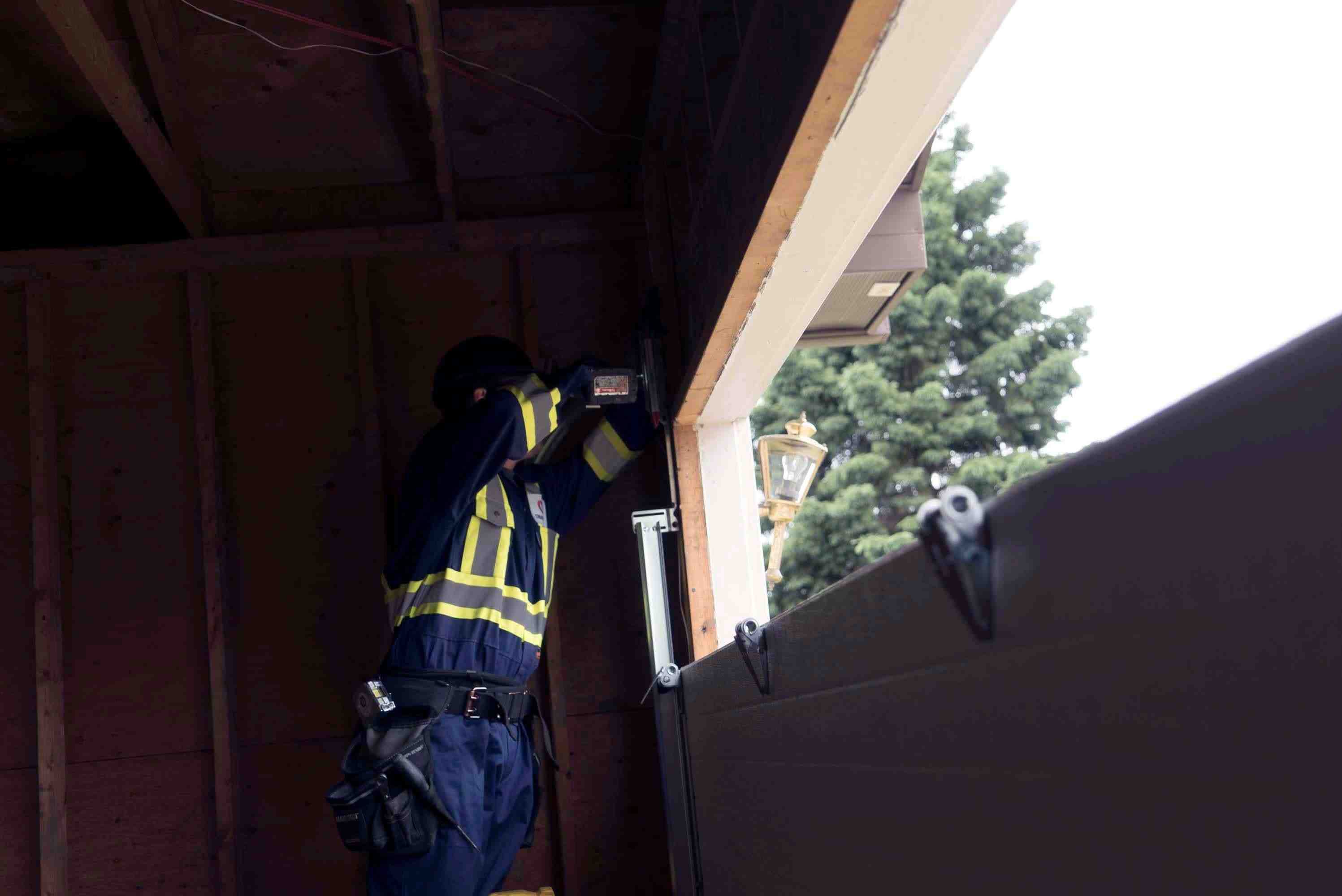 creative door technician working on tracks installation creative door technician working on tracks installation