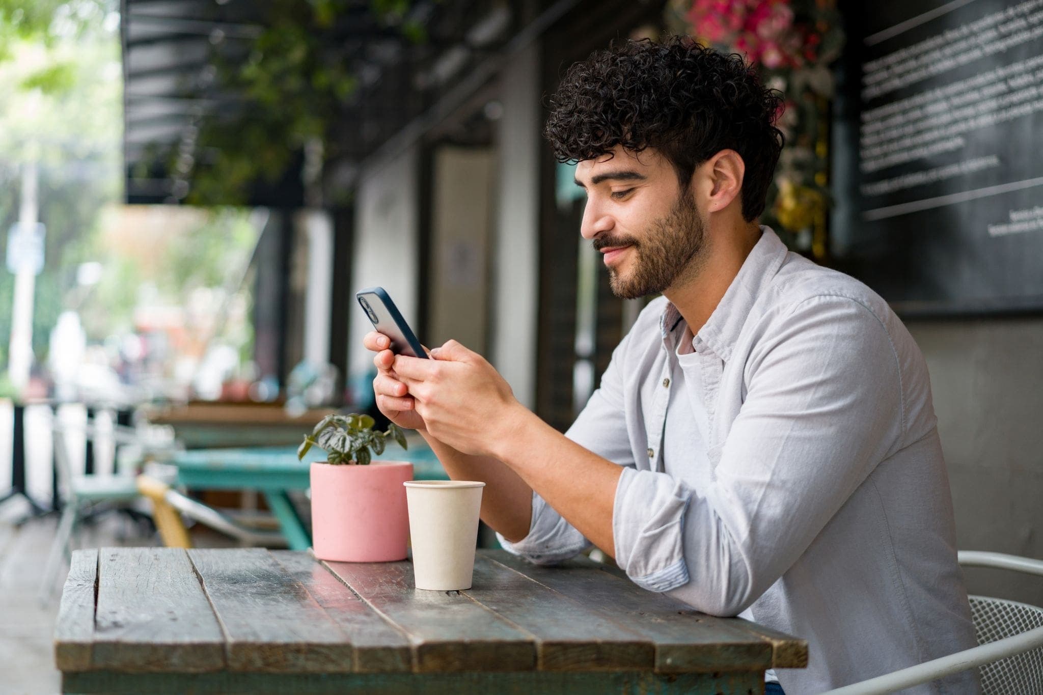 man at cafe checking app for delivery
