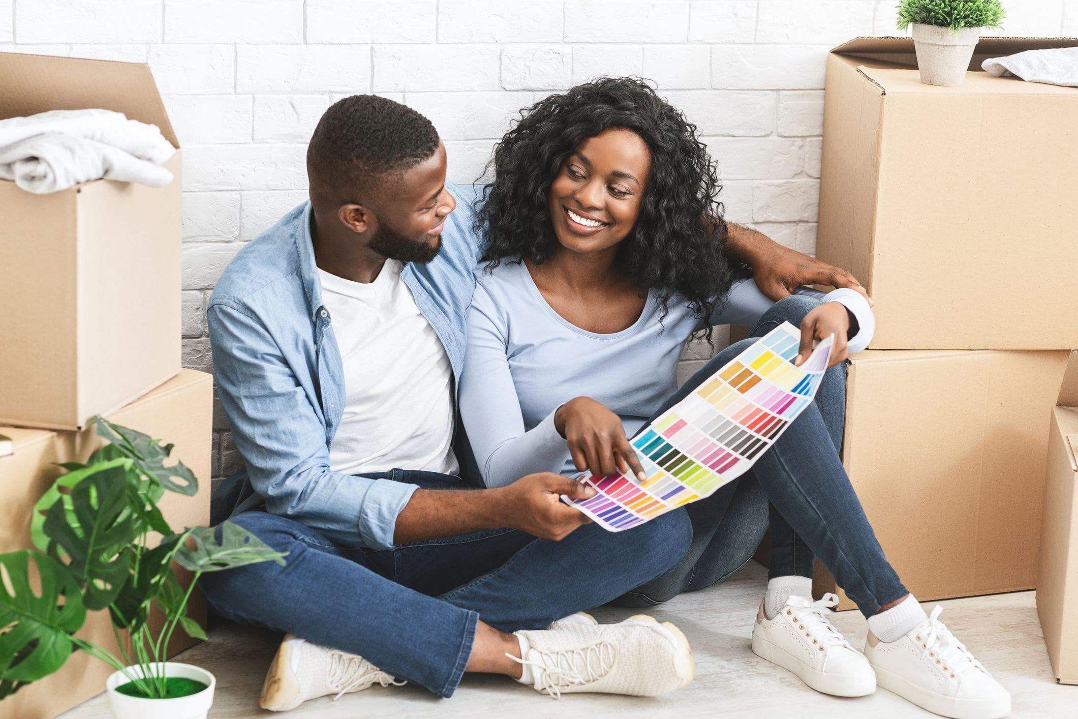 new happy couple choosing paint swabs and colours for home makeover