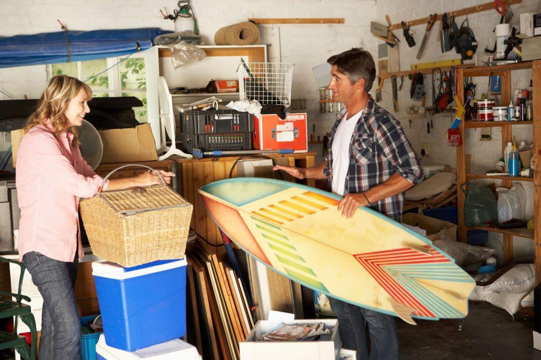 a couple cleaning out and organizing their messy garage