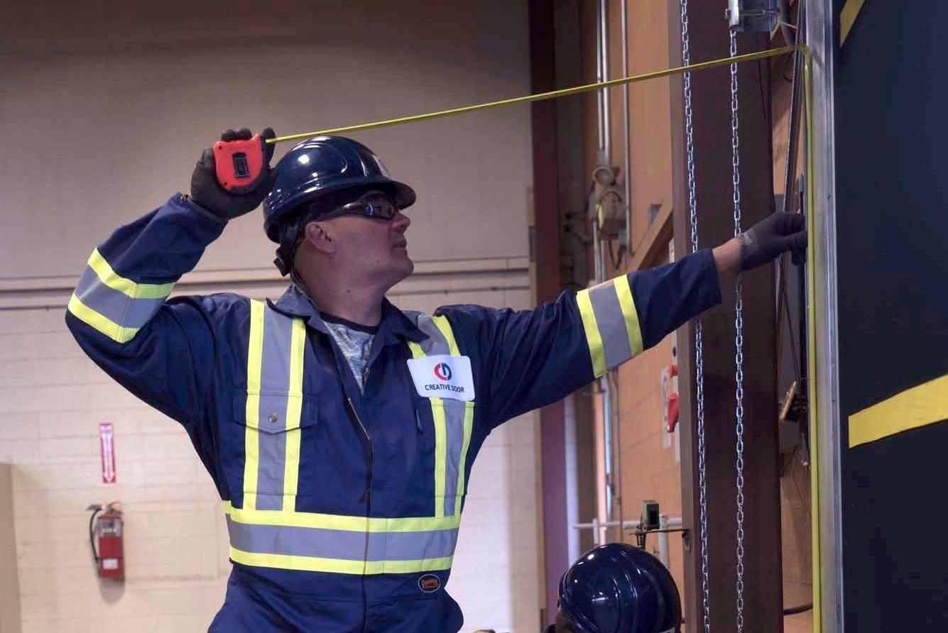 a creative door commercial technician measuring requirements for a new overhead door a creative door commercial technician measuring requirements for a new overhead door