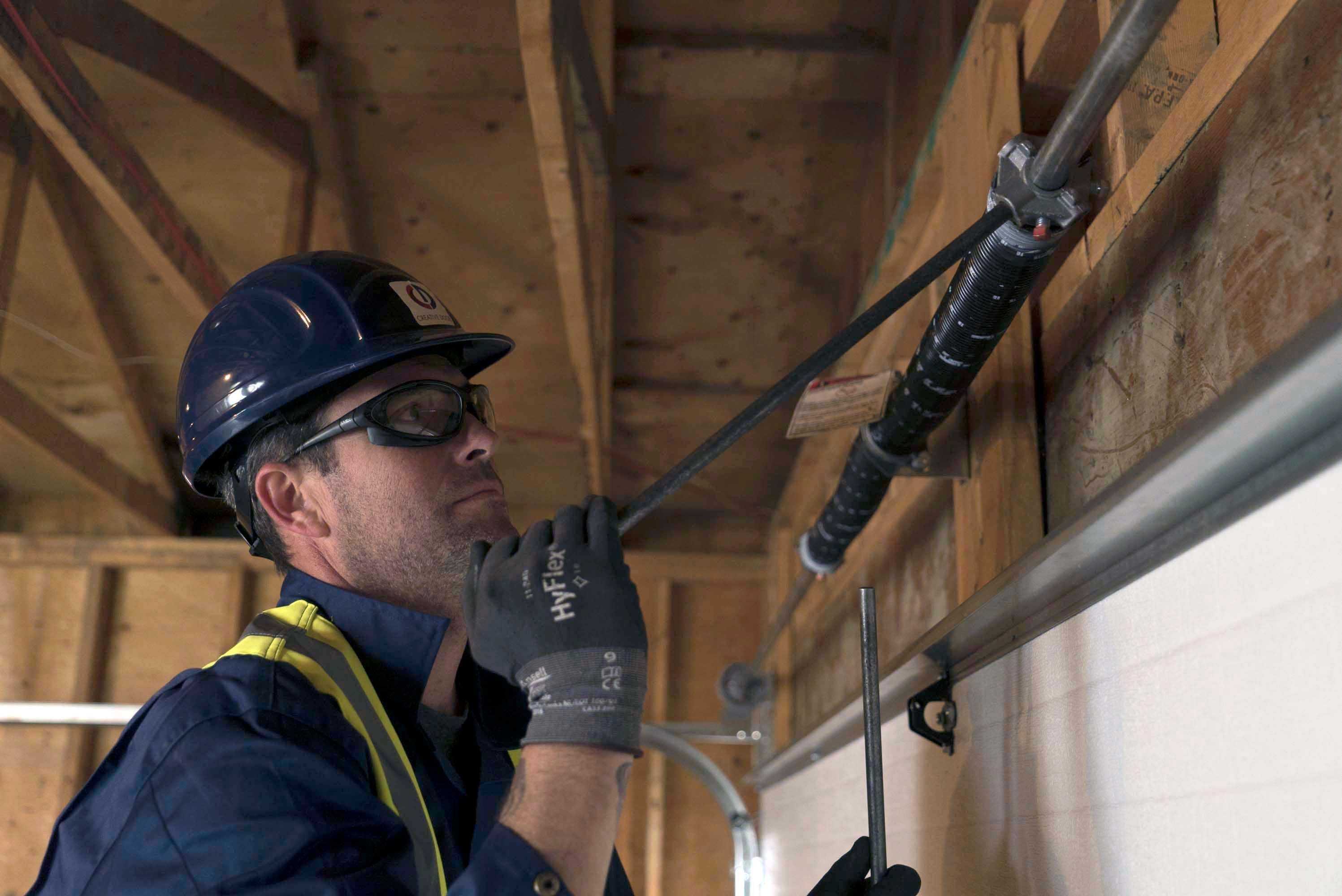 creative door technician performing interior garage maintenance 