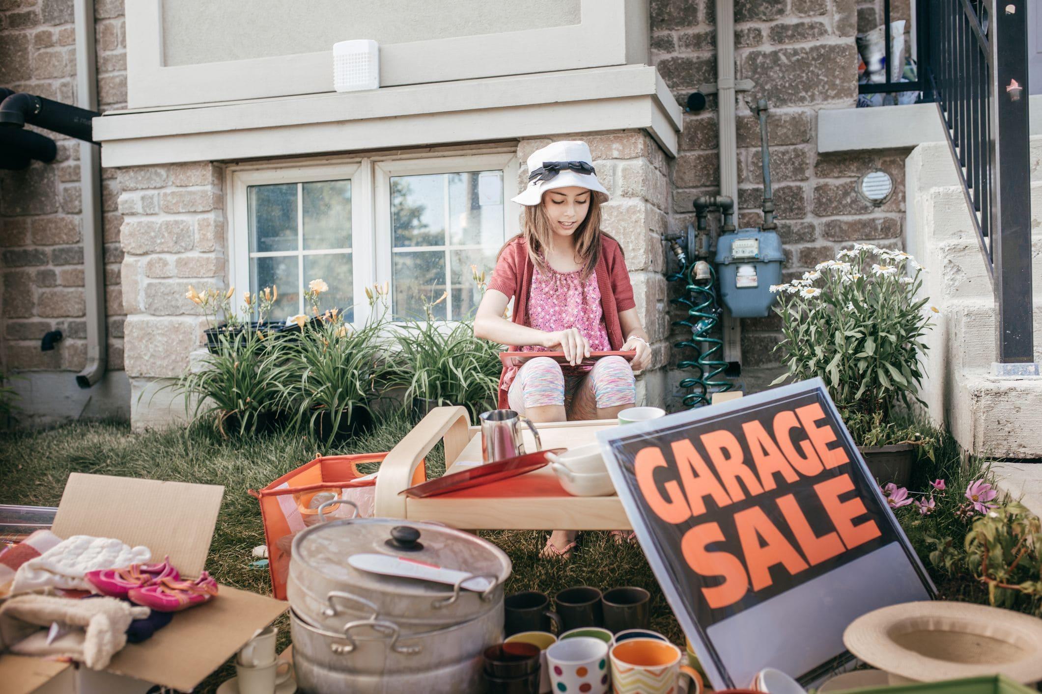 little girl hosting a garage sale to declutter garage on earth day little girl hosting a garage sale to declutter garage on earth day