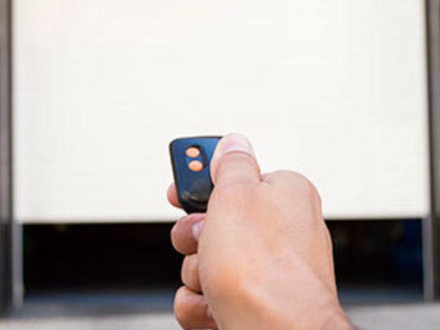 Hand holding garage door opener Hand holding garage door opener