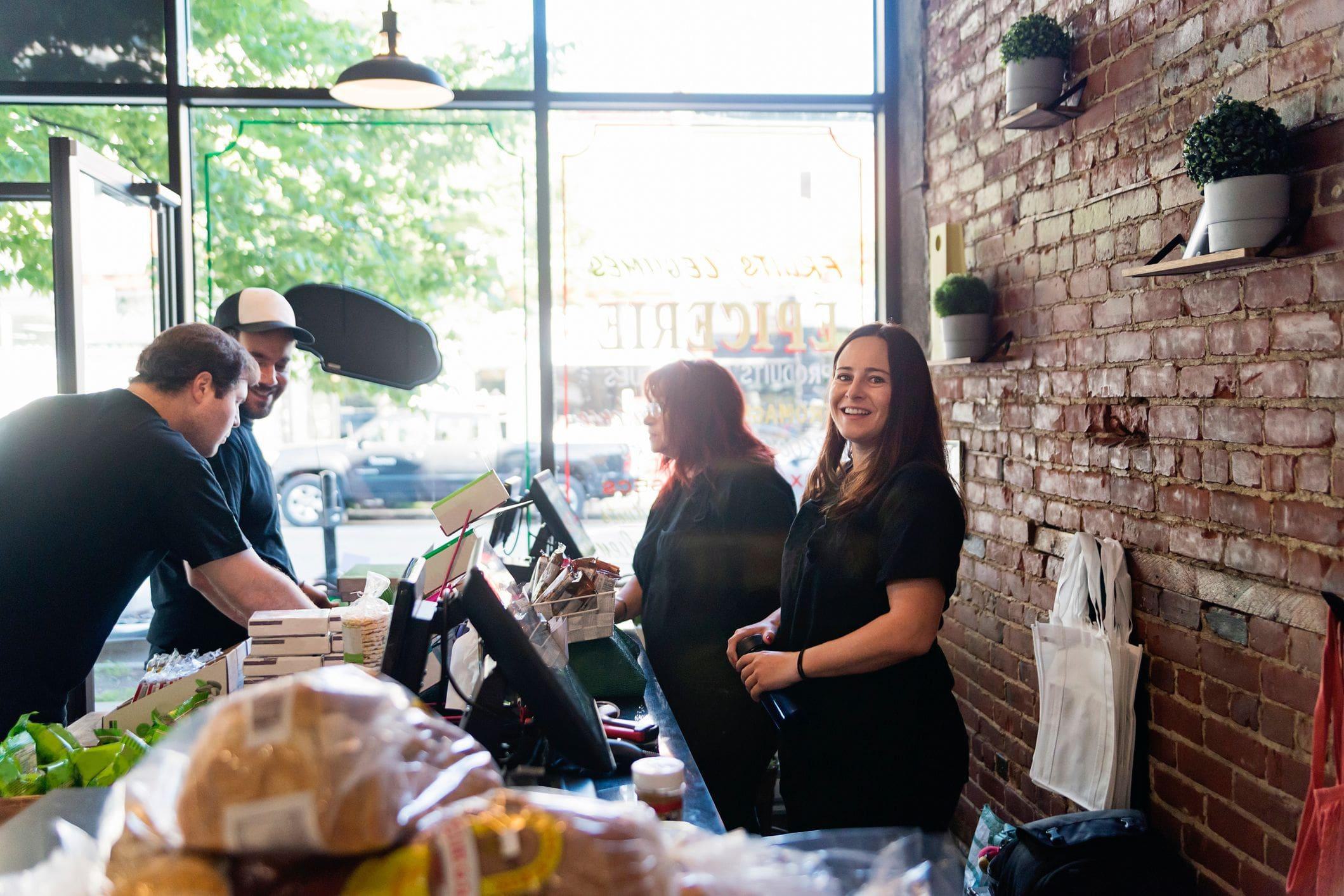 team of employees in a grocery storefront with large streetfront windows team of employees in a grocery storefront with large streetfront windows