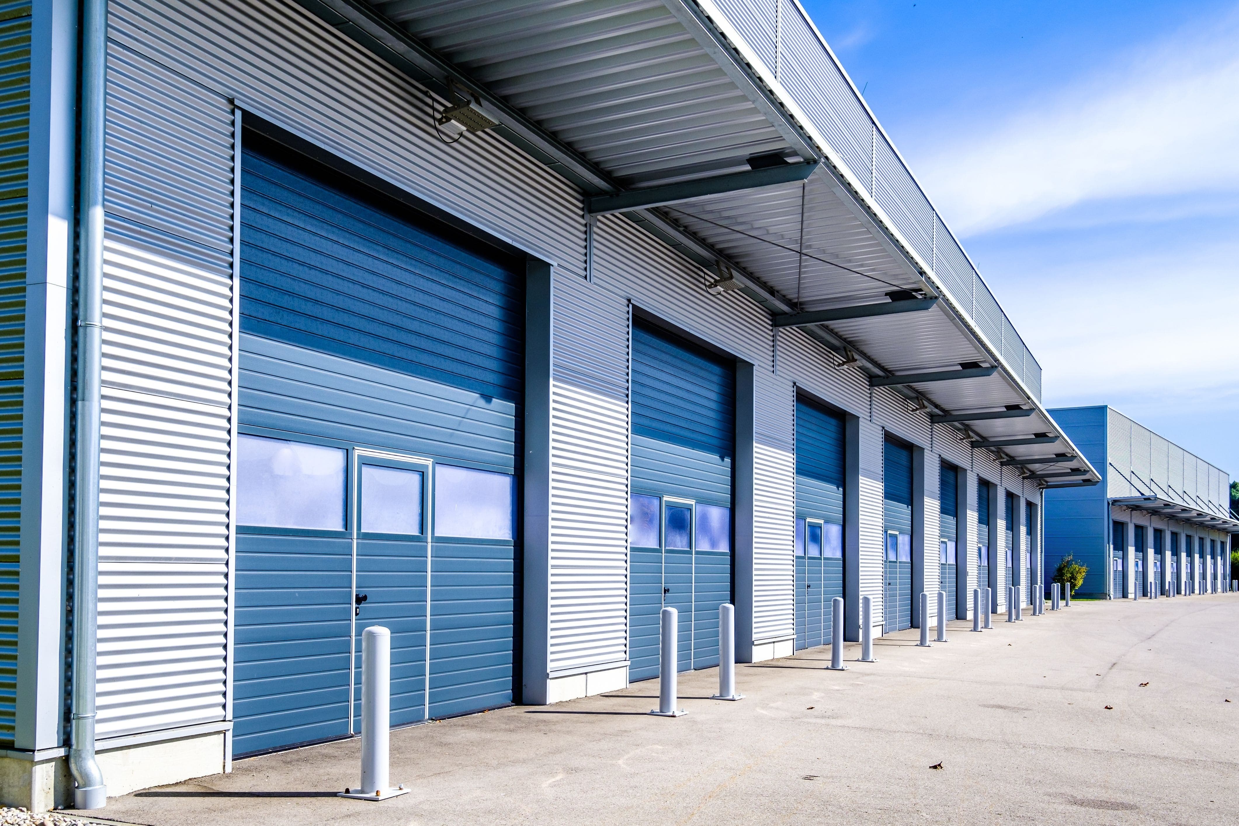 an exterior view of a line of commercial rolling doors at a plant or warehouse
