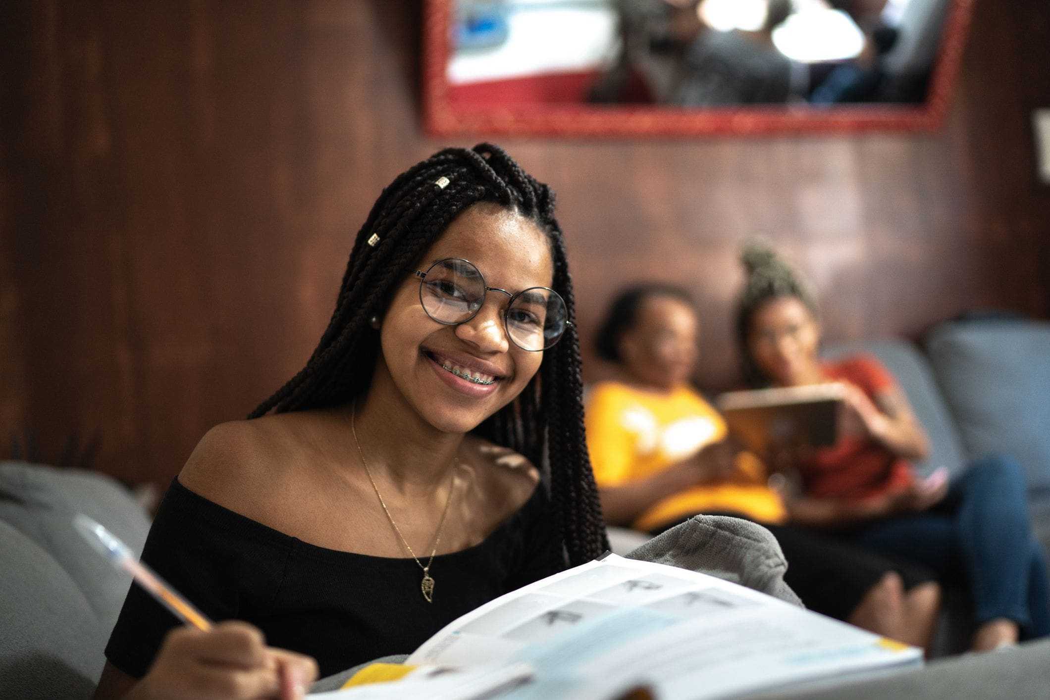 young girl smiling with homework with family in garage background young girl smiling with homework with family in garage background