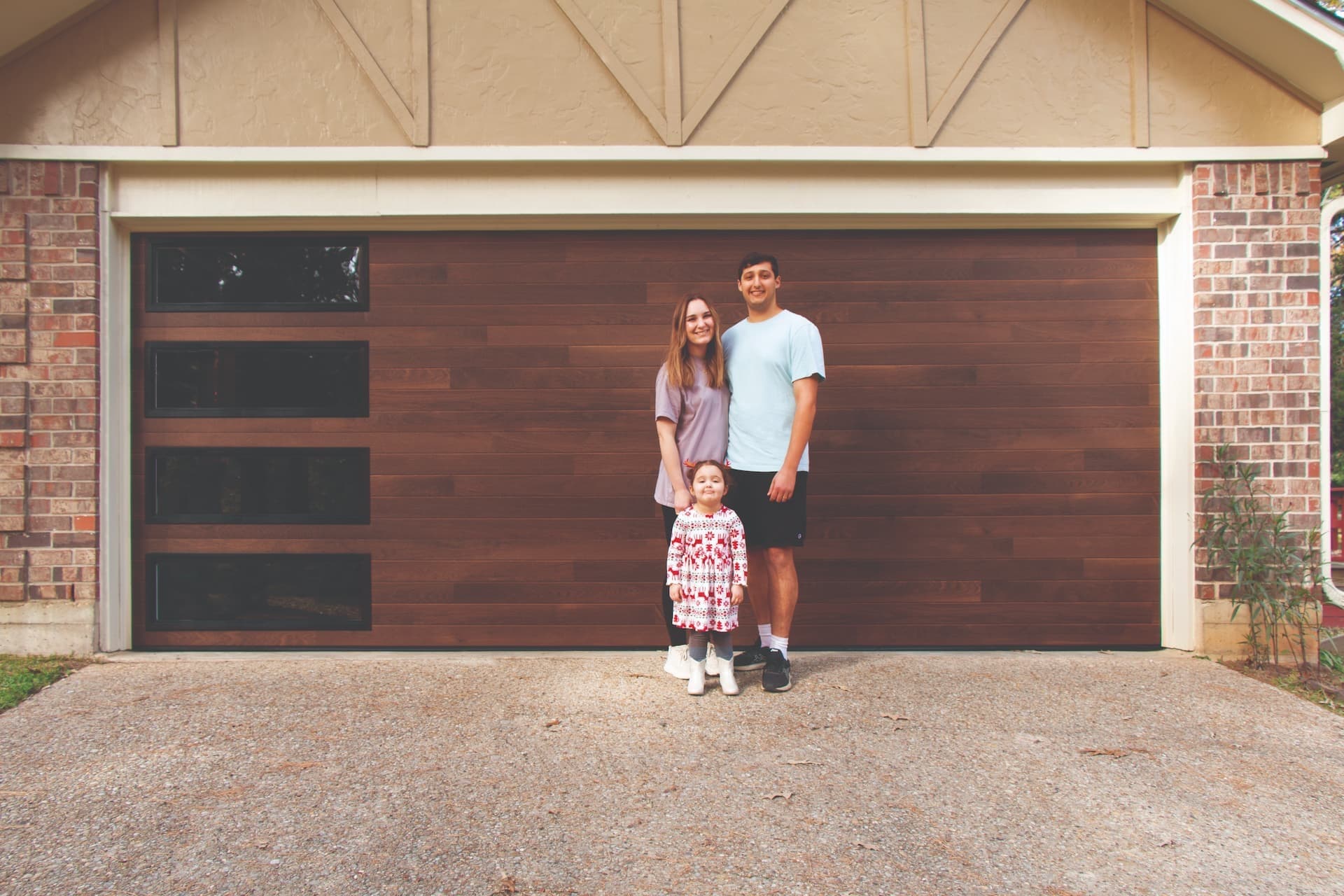 family standing in front of wood garage door
