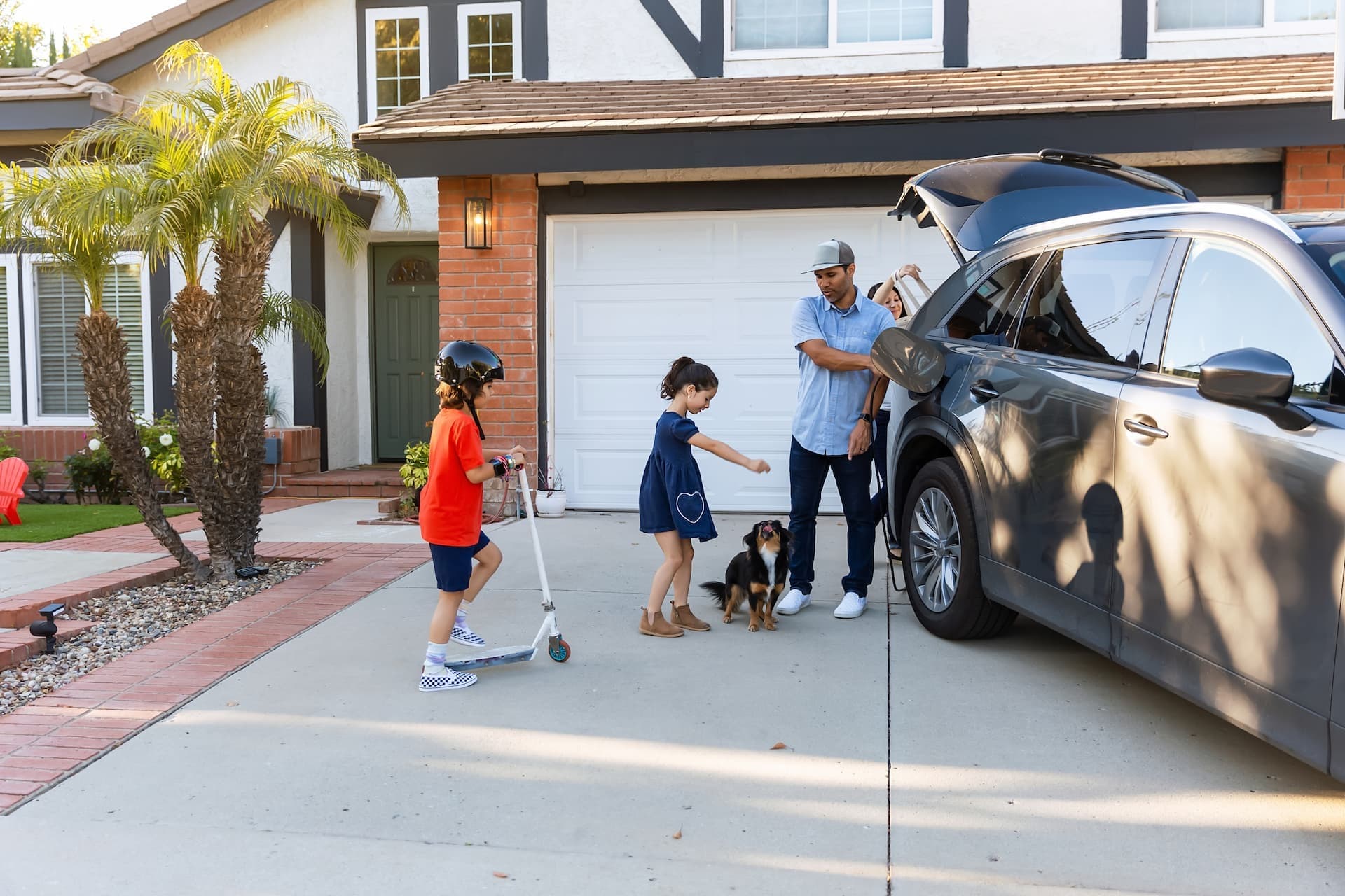 family unloading car in front of garage