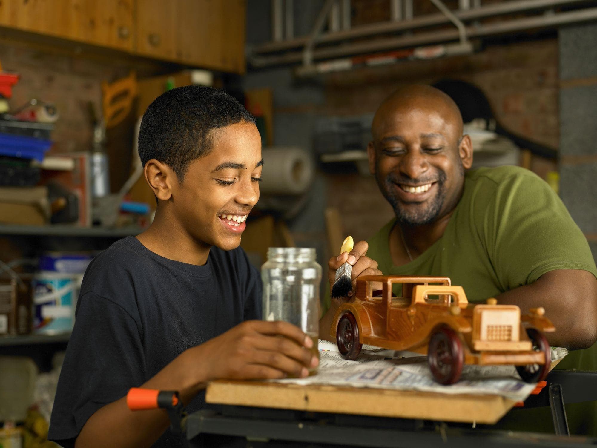 father admiring son's woodworking project in home garage