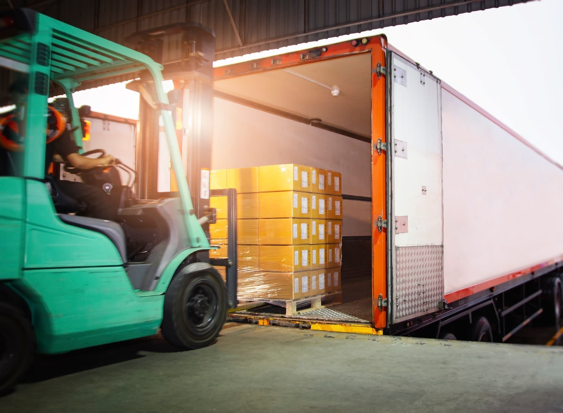 forklift driver loading cargo onto docked truck