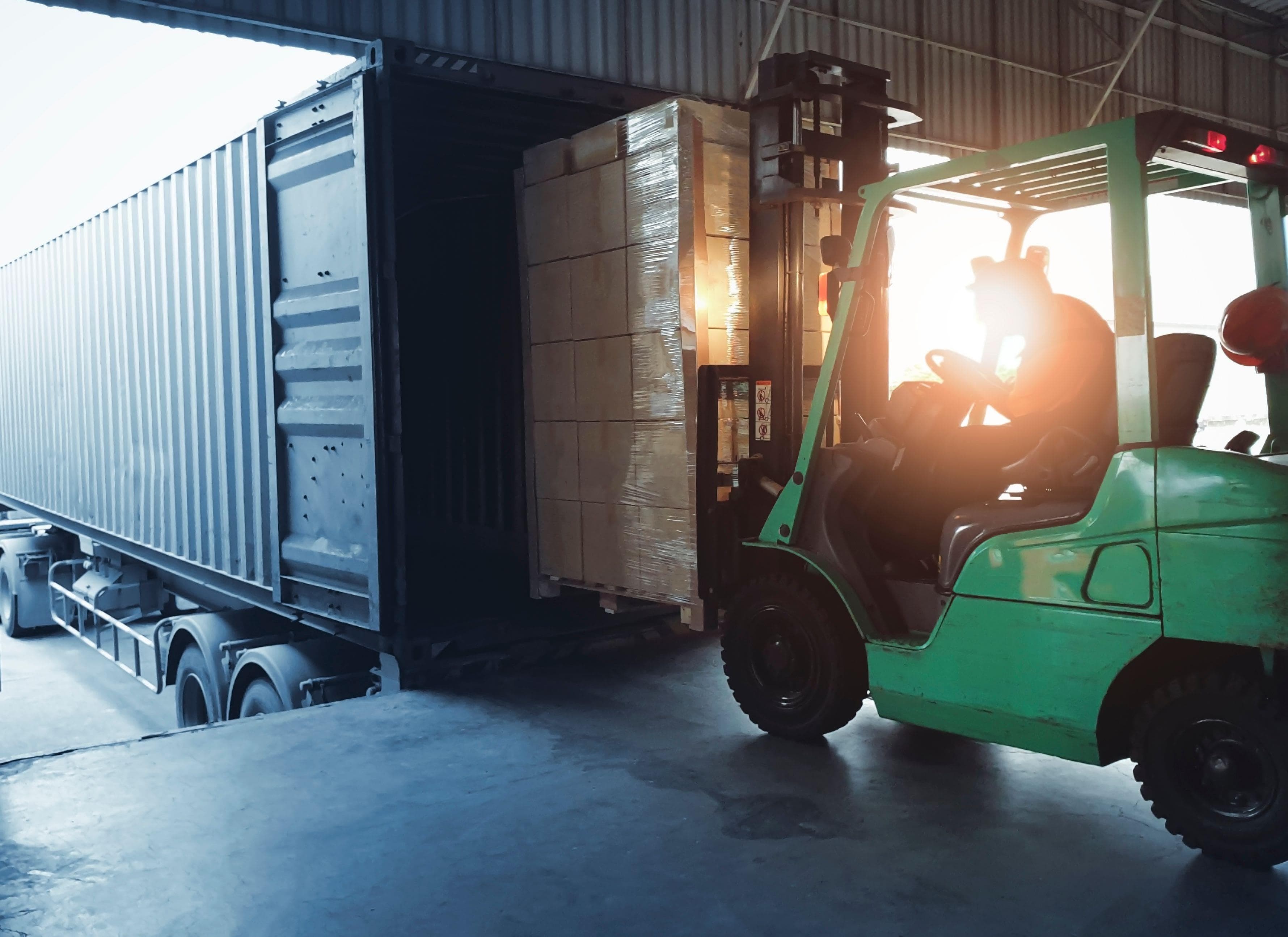 forklift bringing boxes into loading area of commercial warehouse