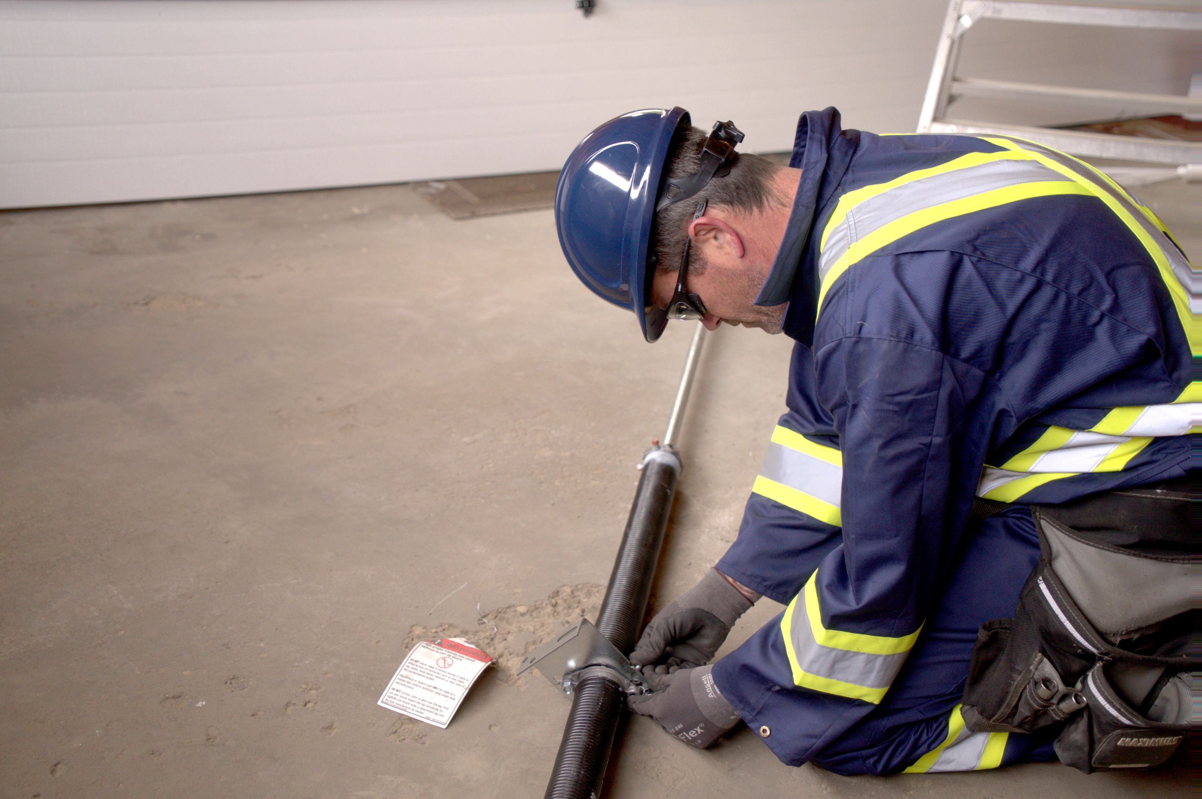 garage door technician preparing torsion springs for garage door repair