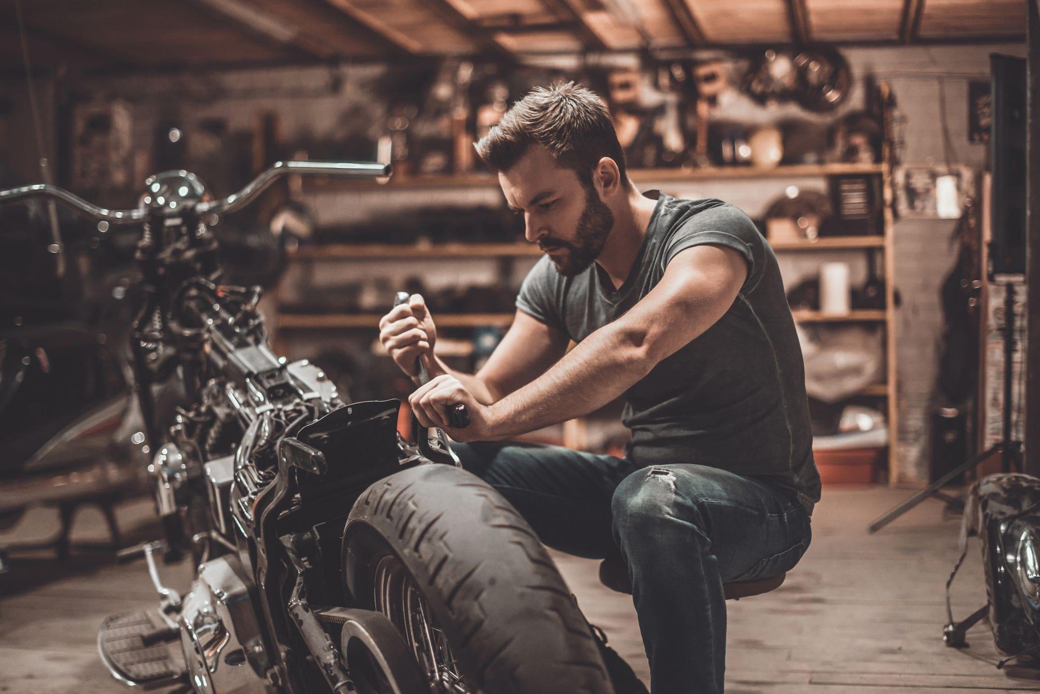 man in home garage working on motorbike