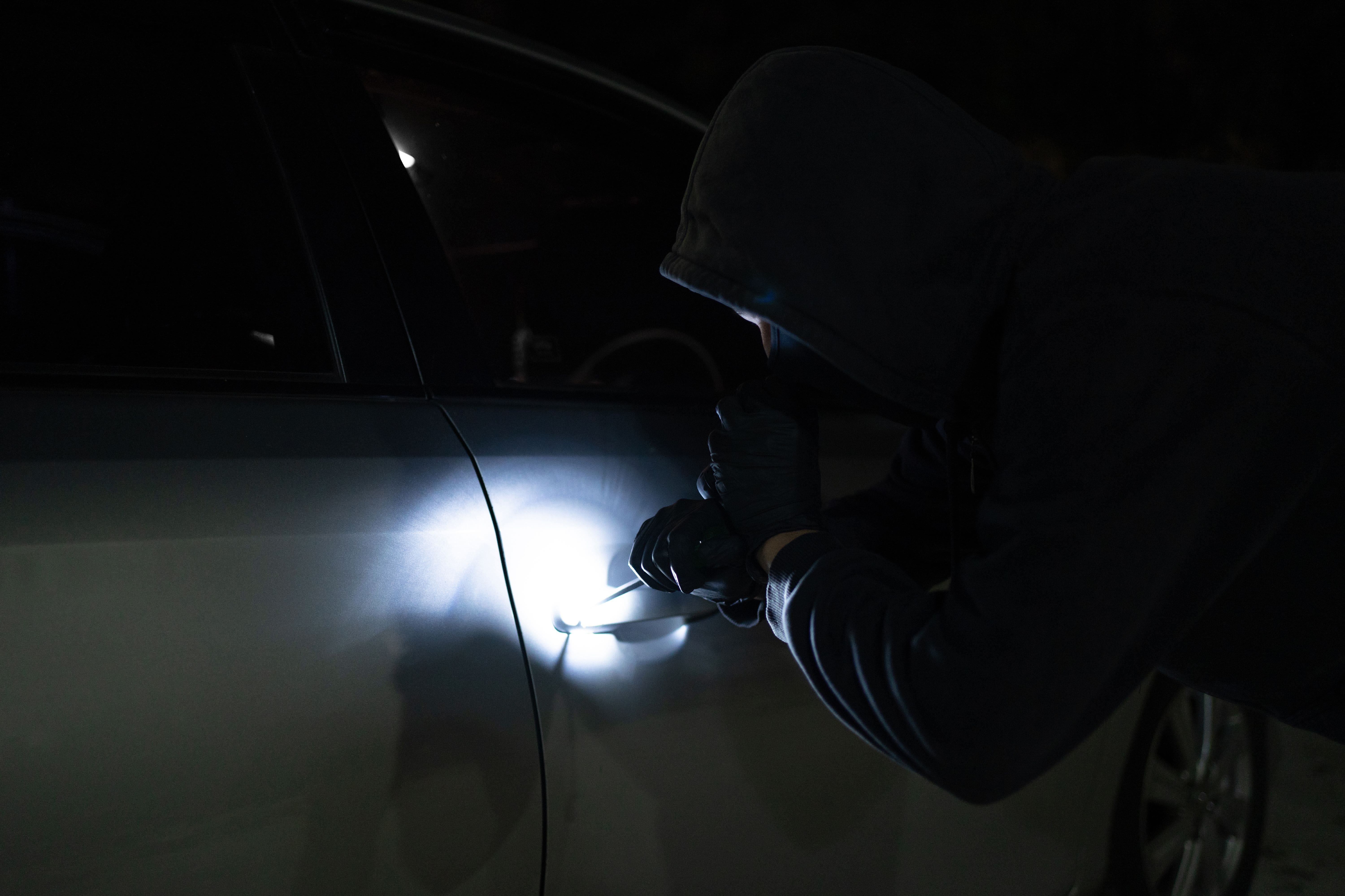 a burglar attempting to break in to a car in a garage