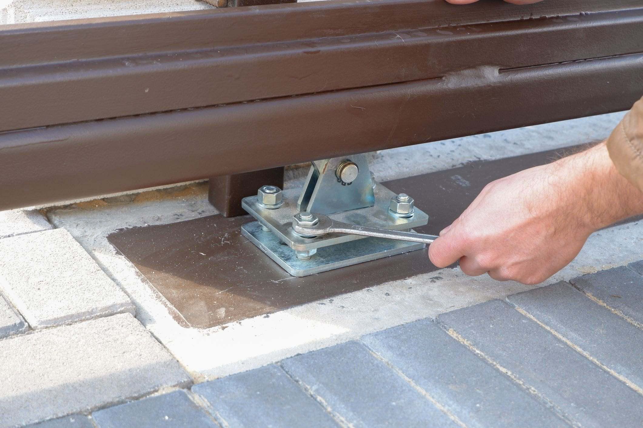 technician tightening hardware for gate tracks