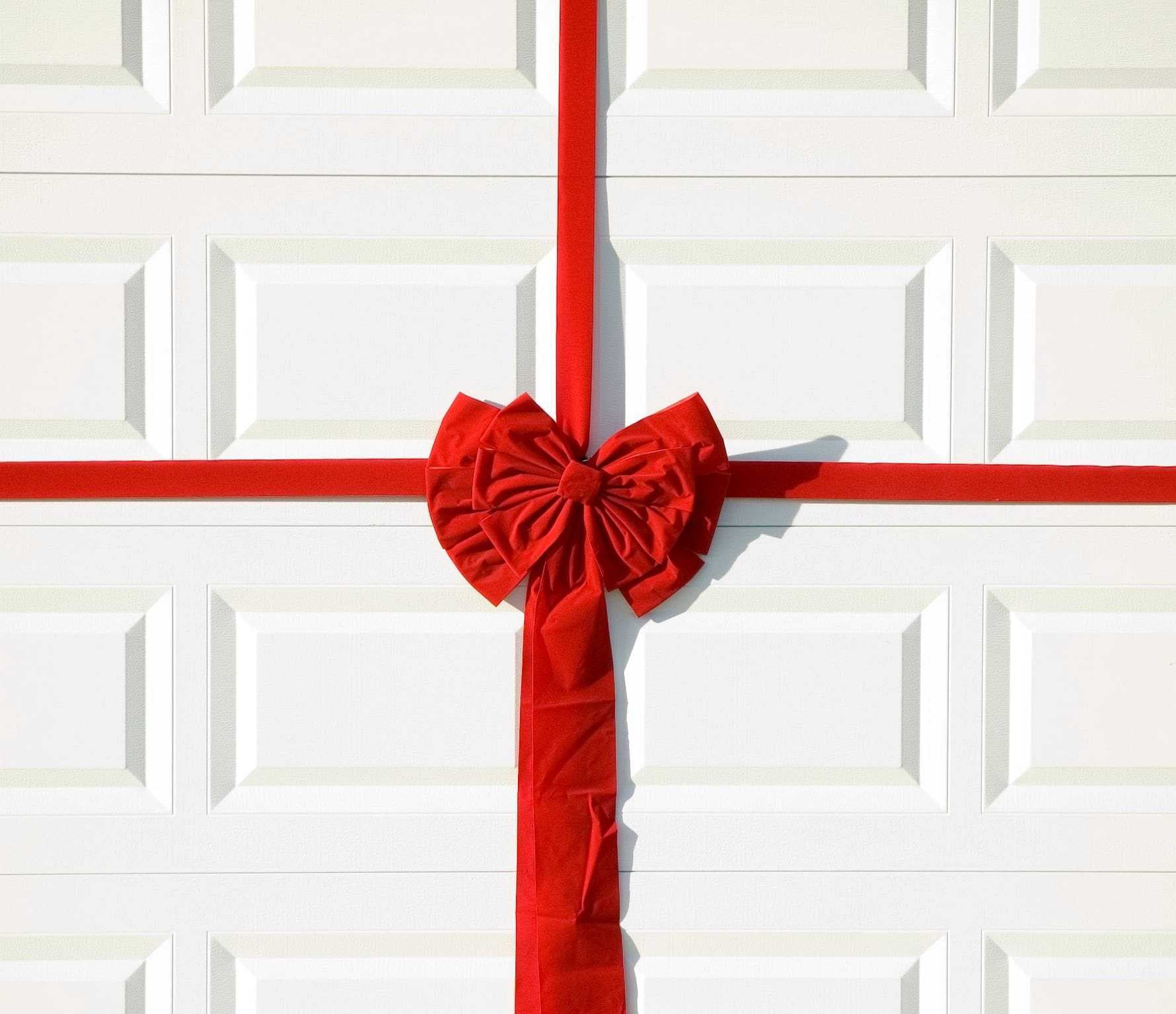 a big red bow tied around a white garage door