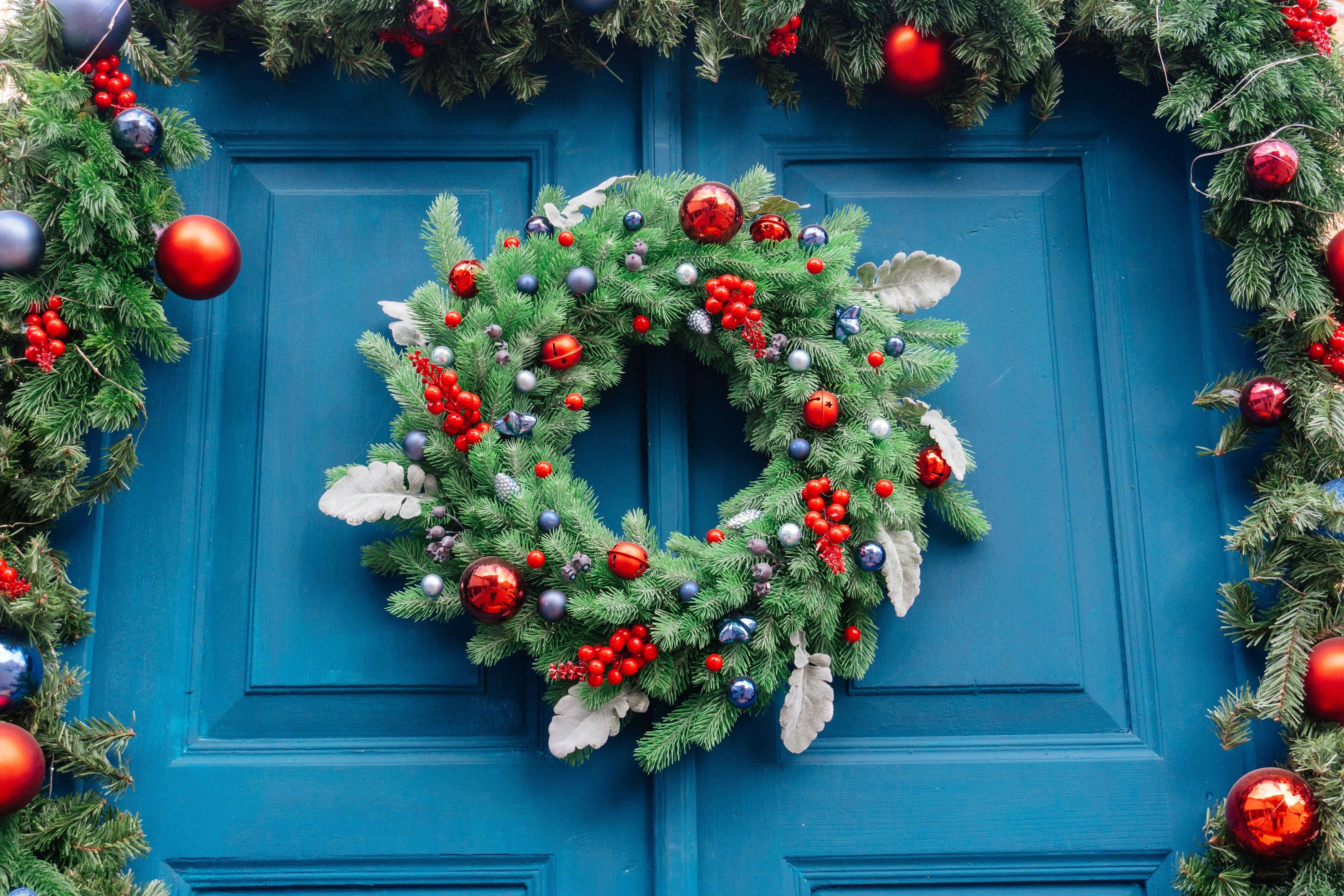 perfect holiday wreath and garland on a blue door