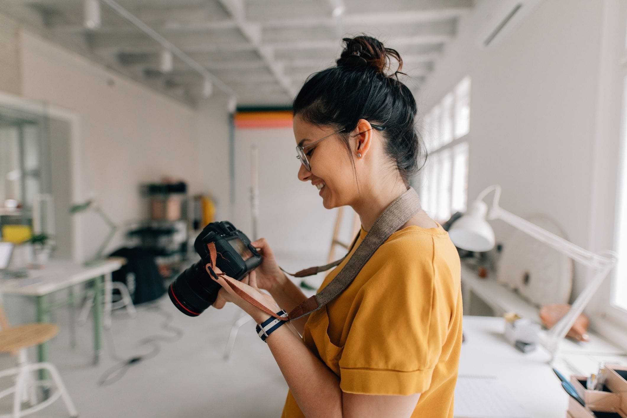 woman holding camera inside home photography studio with double access point garage doors