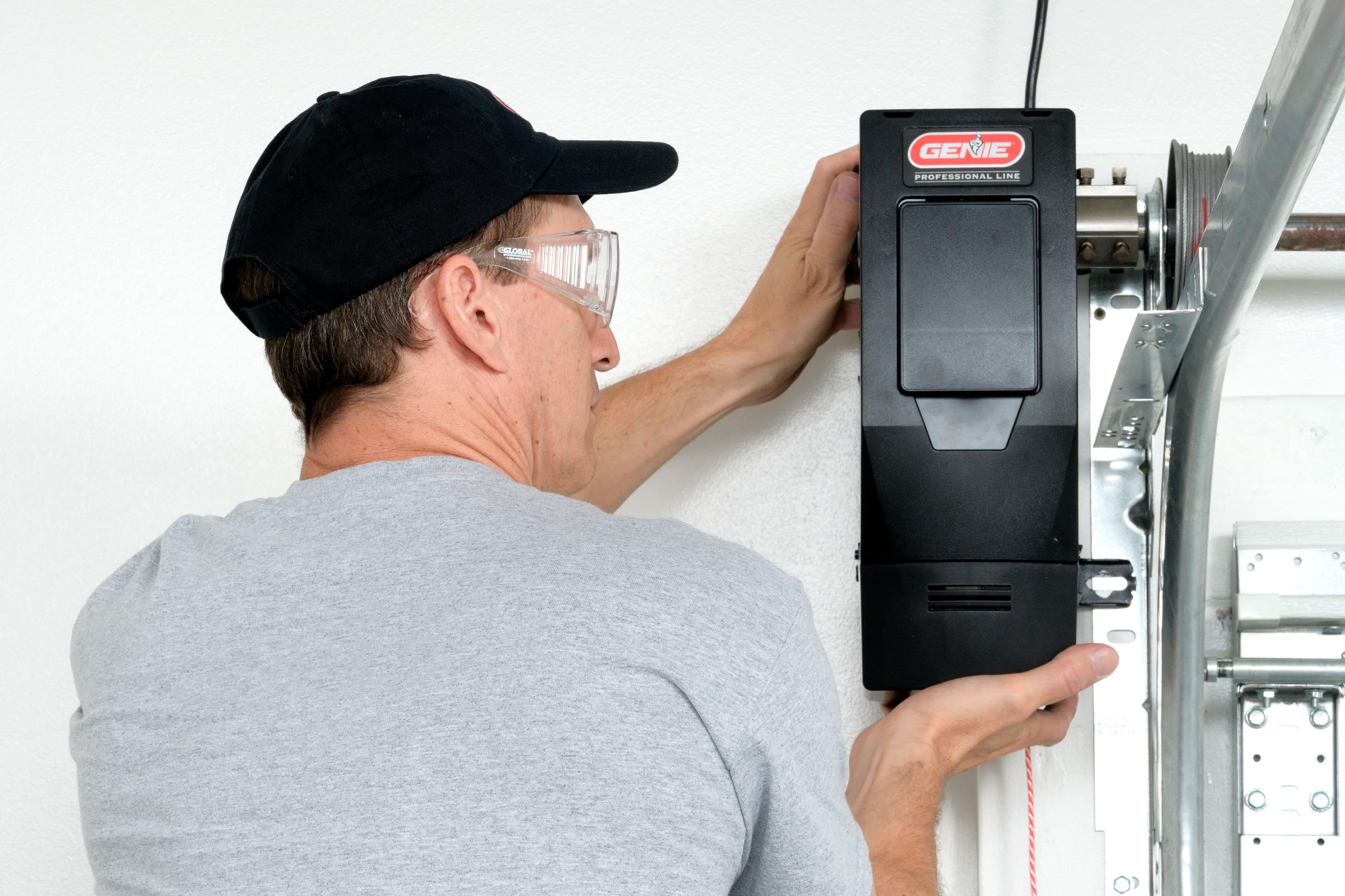 technician inspecting and resetting genie opener operating system for garage doors