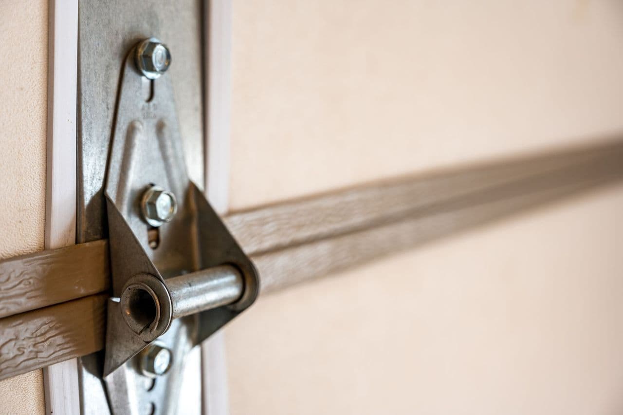 a close up of an interior of a garage door with hinge and seal visible