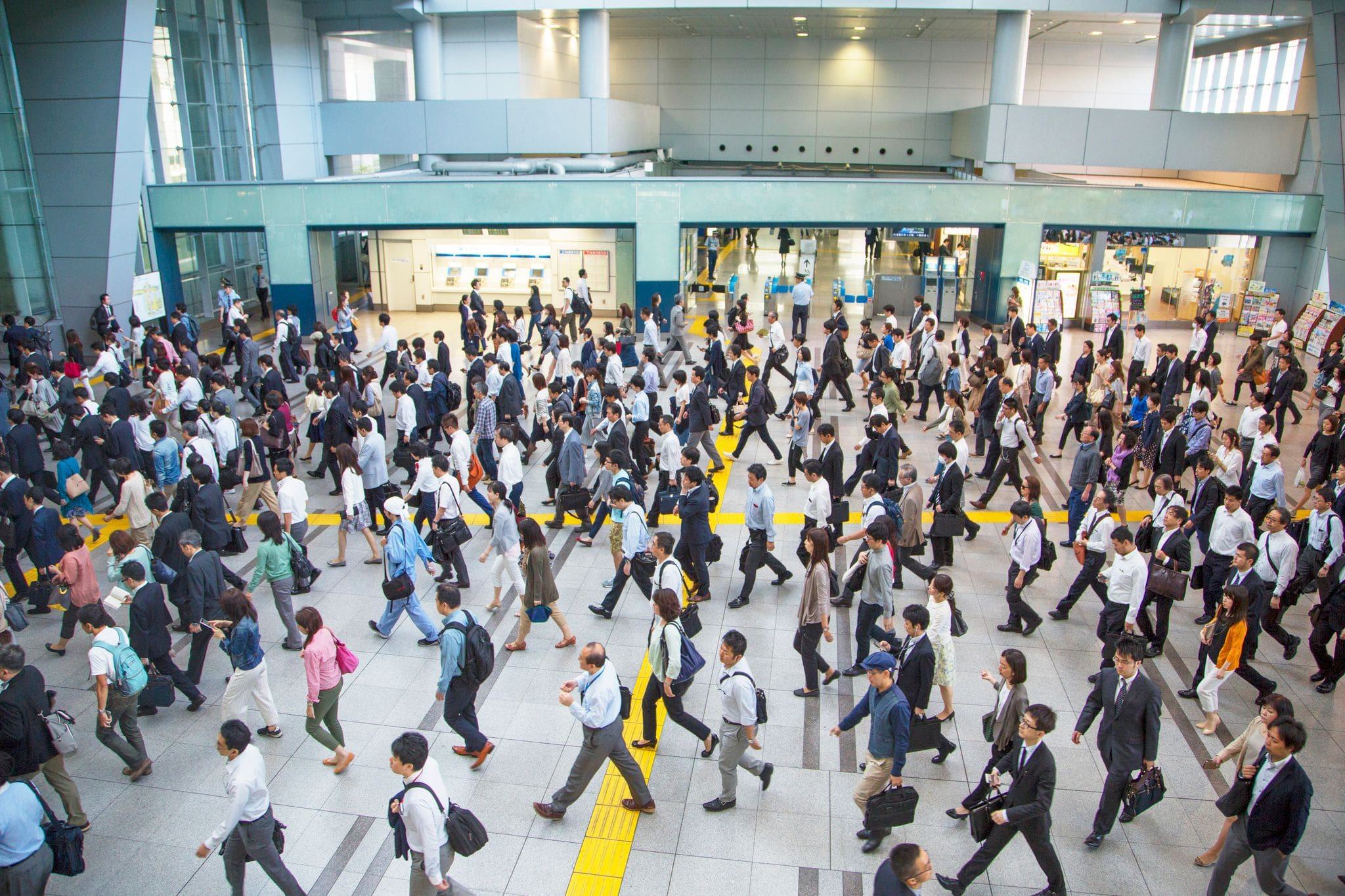 a very busy crowded station with pedestrians walking to their gates