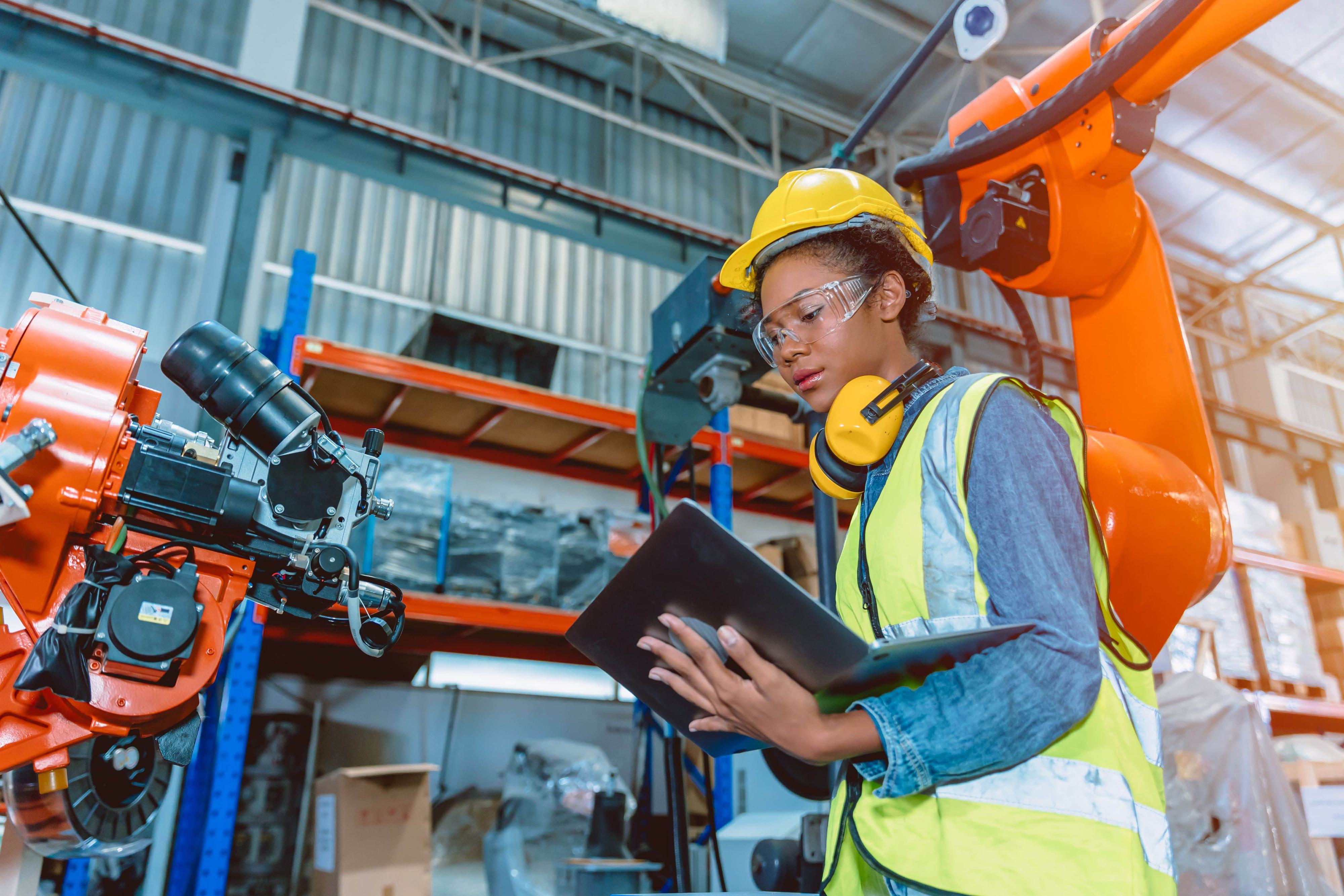 a woman walks through her checklist in a large manufacturing facility