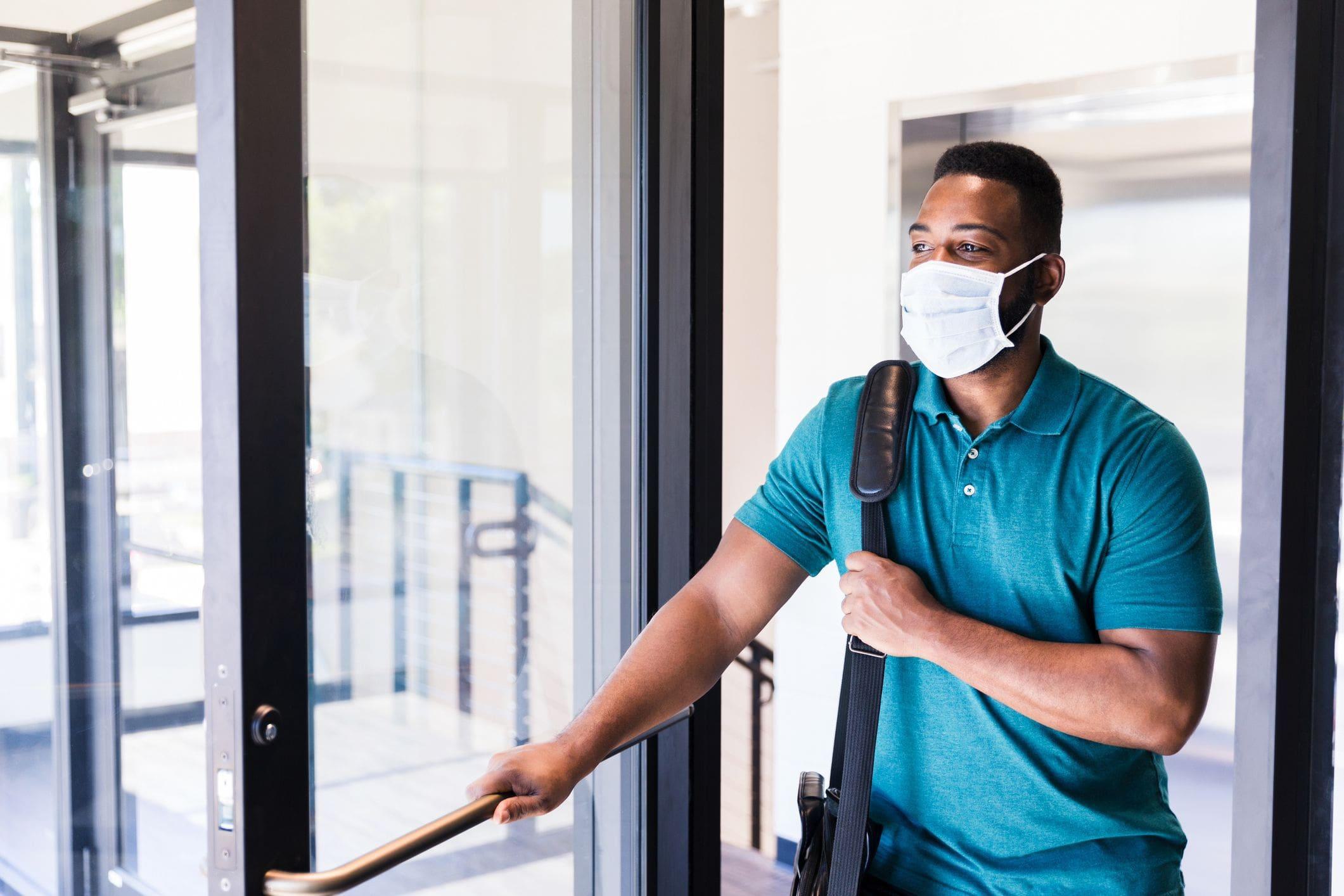 man arriving at work wearing mask and with keycard man arriving at work wearing mask and with keycard