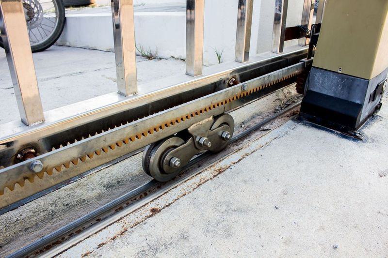 sliding gate components including wheel and gears on a track