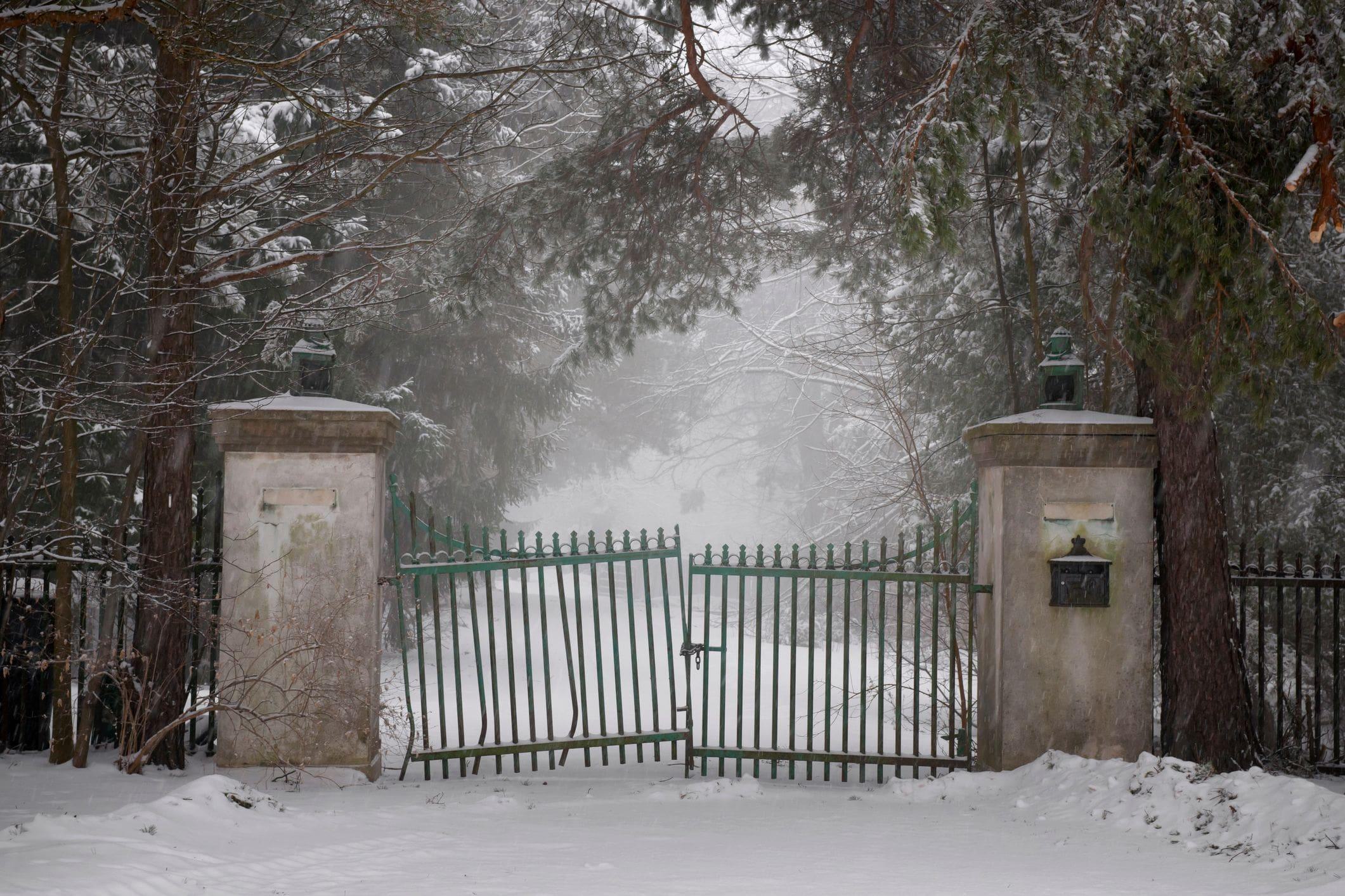 snowy driveway with a neglected run down gate snowy driveway with a neglected run down gate