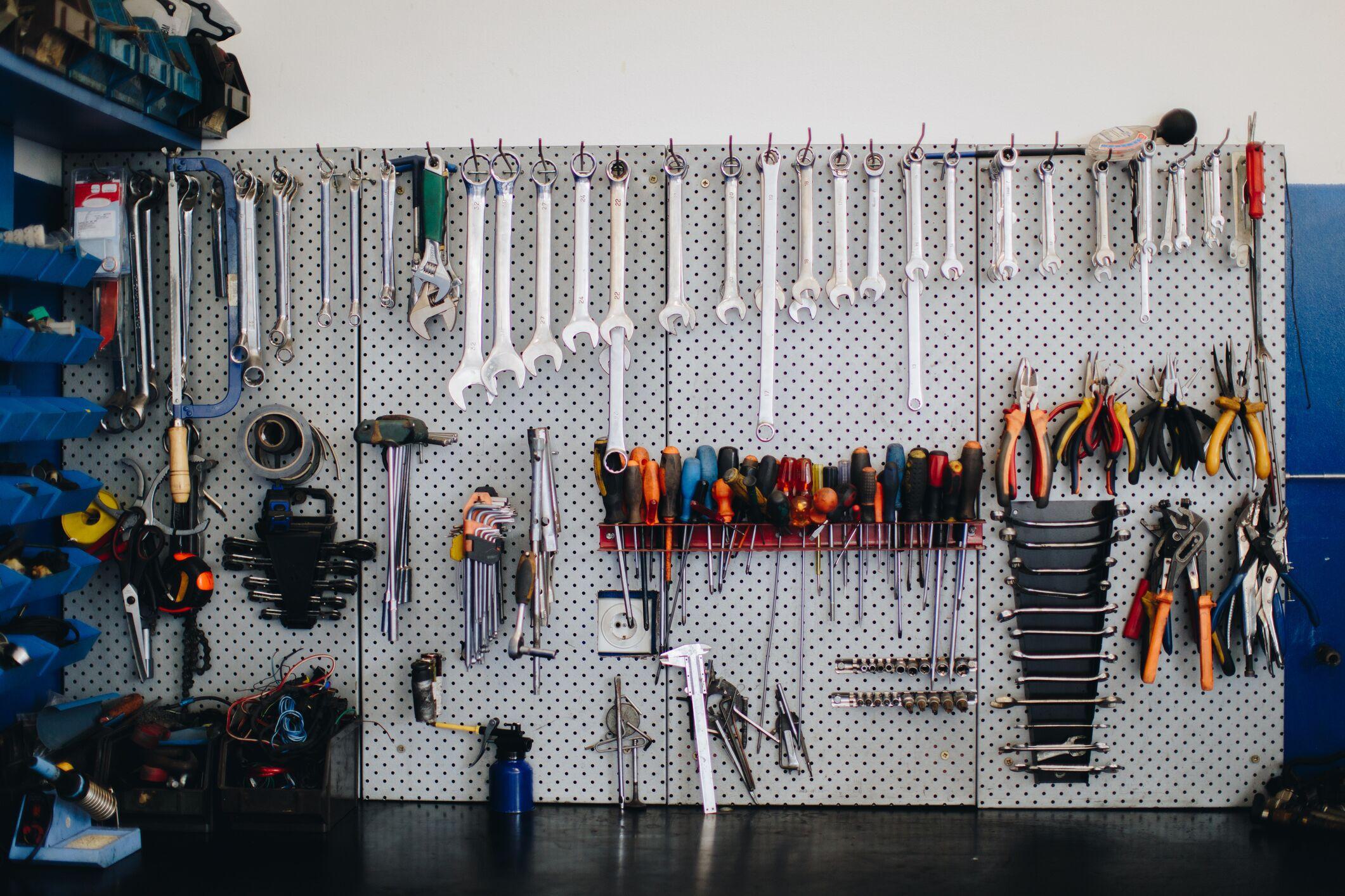 clean and organized tools hanging on a pegboard with hooks clean and organized tools hanging on a pegboard with hooks