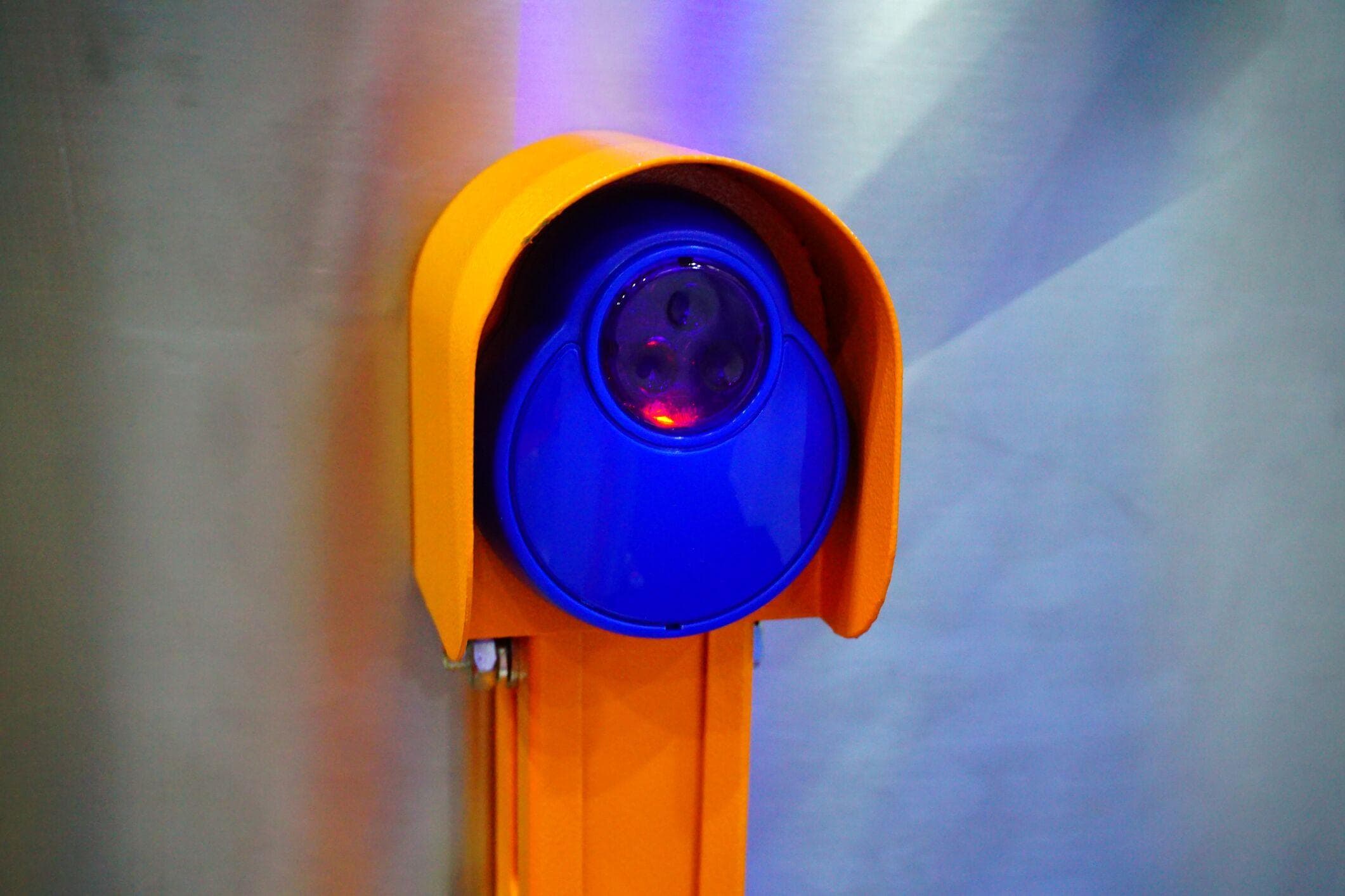 close up of photo eye sensors painted orange and blue