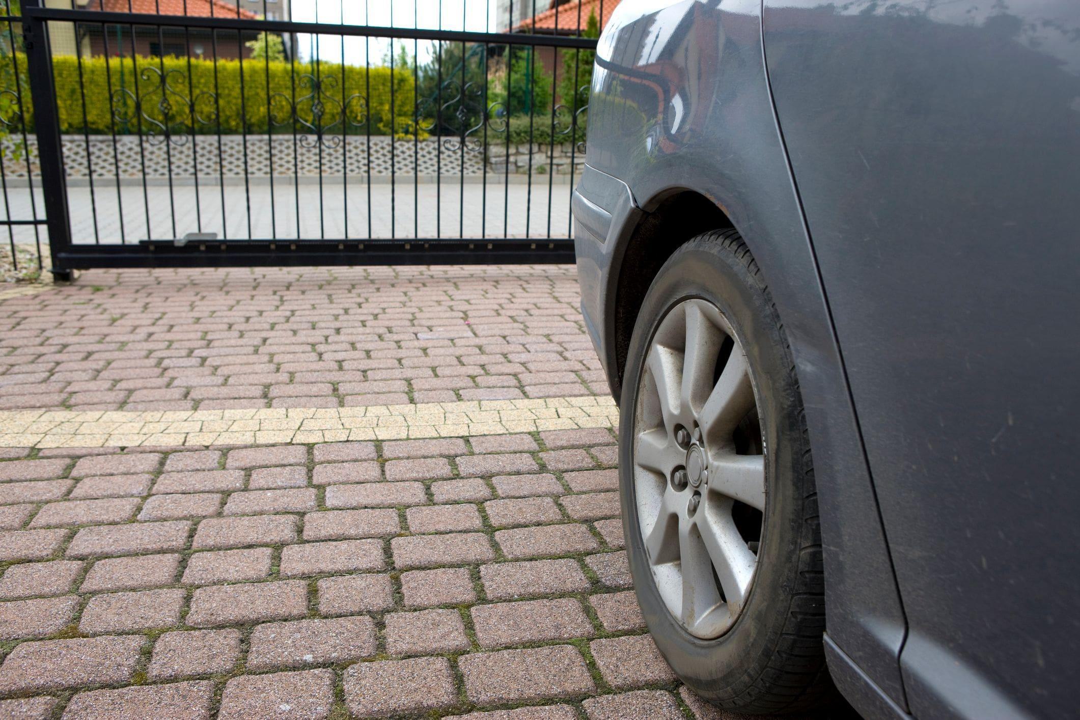 a private driveway with closed sliding metal gate a private driveway with closed sliding metal gate