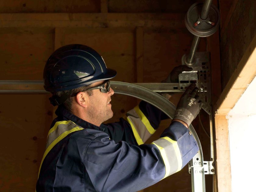 Creative Door Services technician repairing garage door