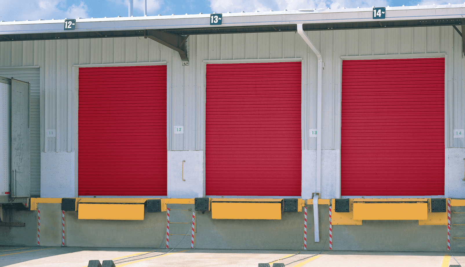three red rolling doors at a commercial loading dock