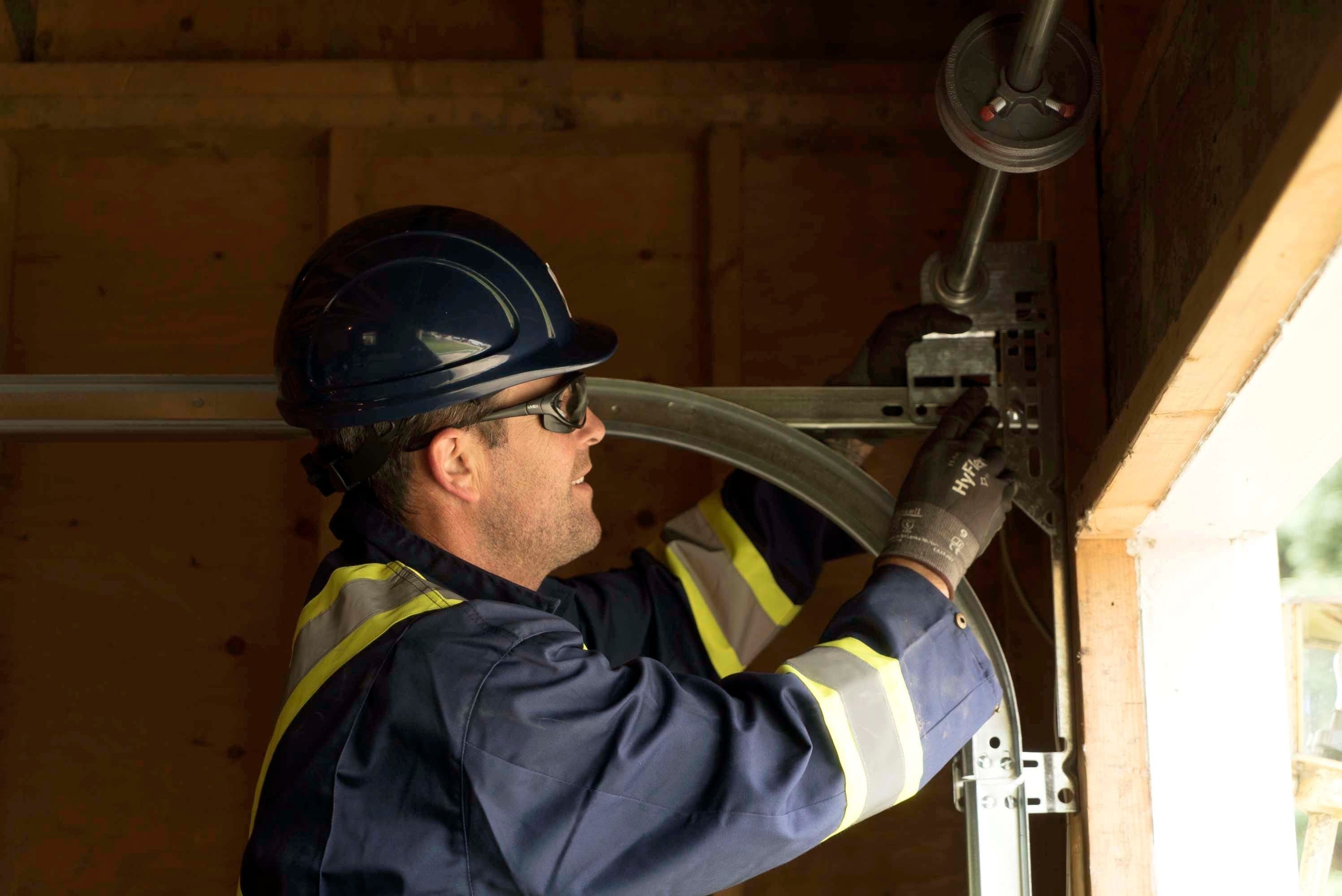 technician performing garage door residential service inspection