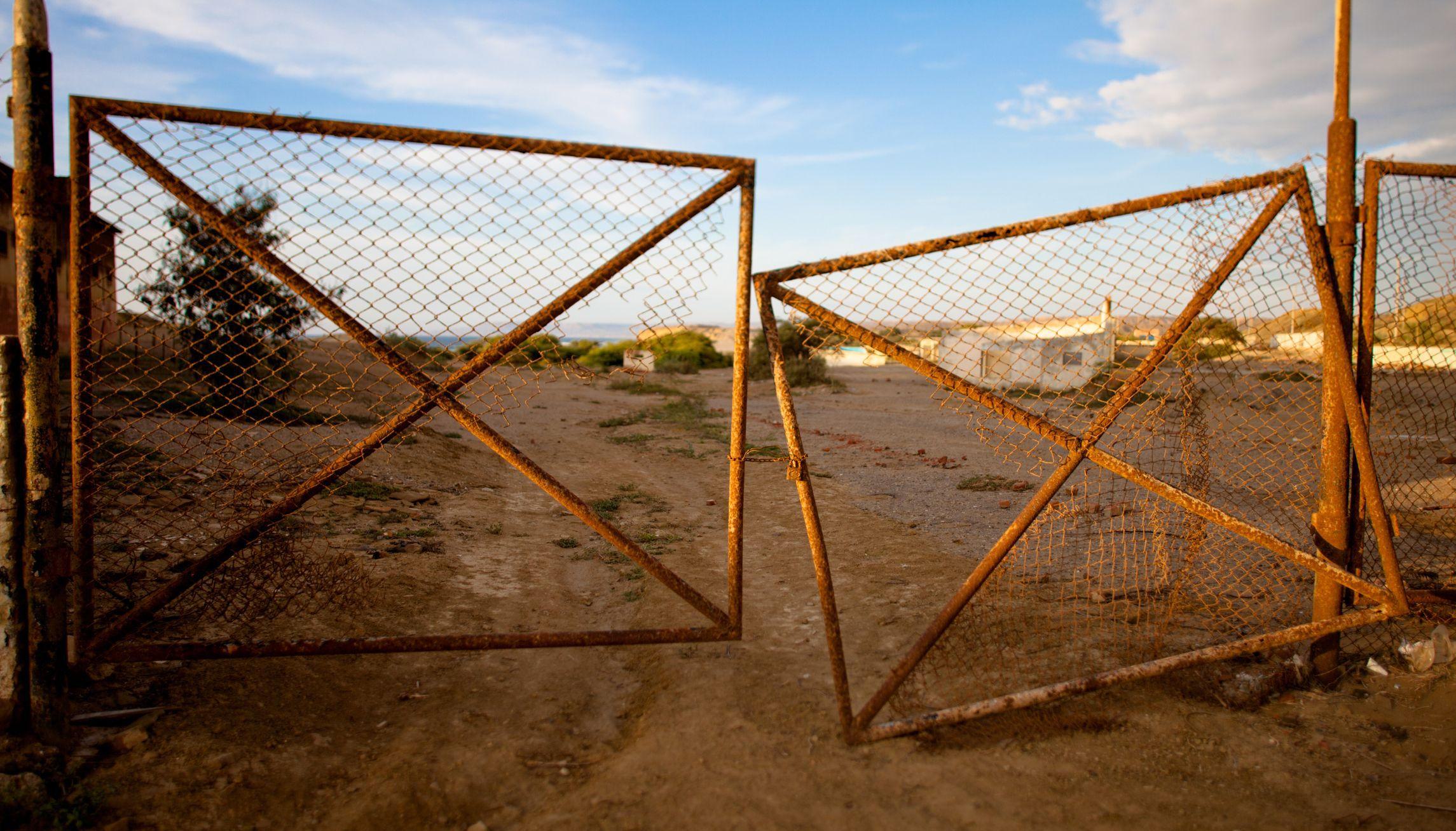old rusty broken gate hanging open old rusty broken gate hanging open
