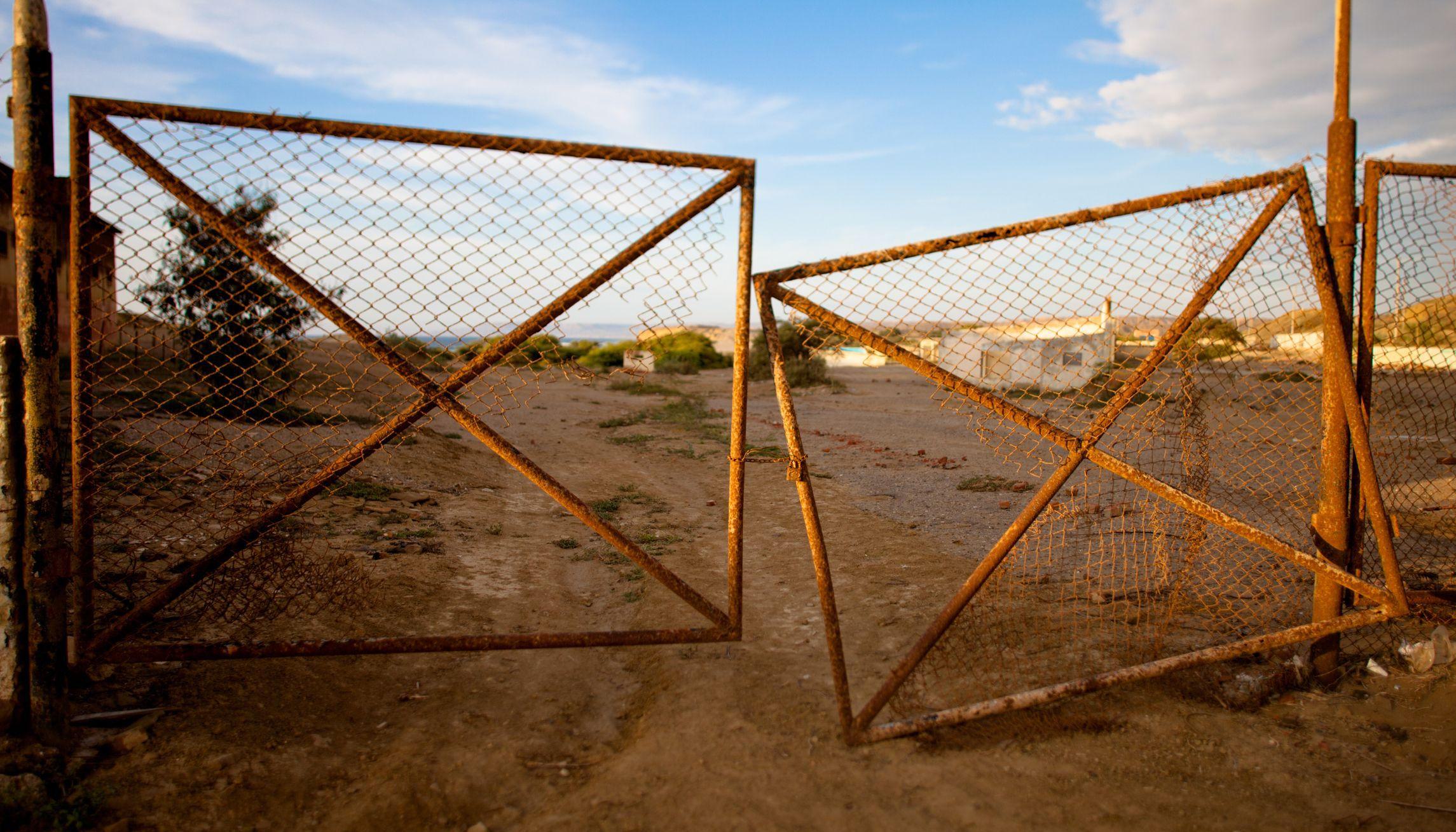 old rusty broken gate hanging open