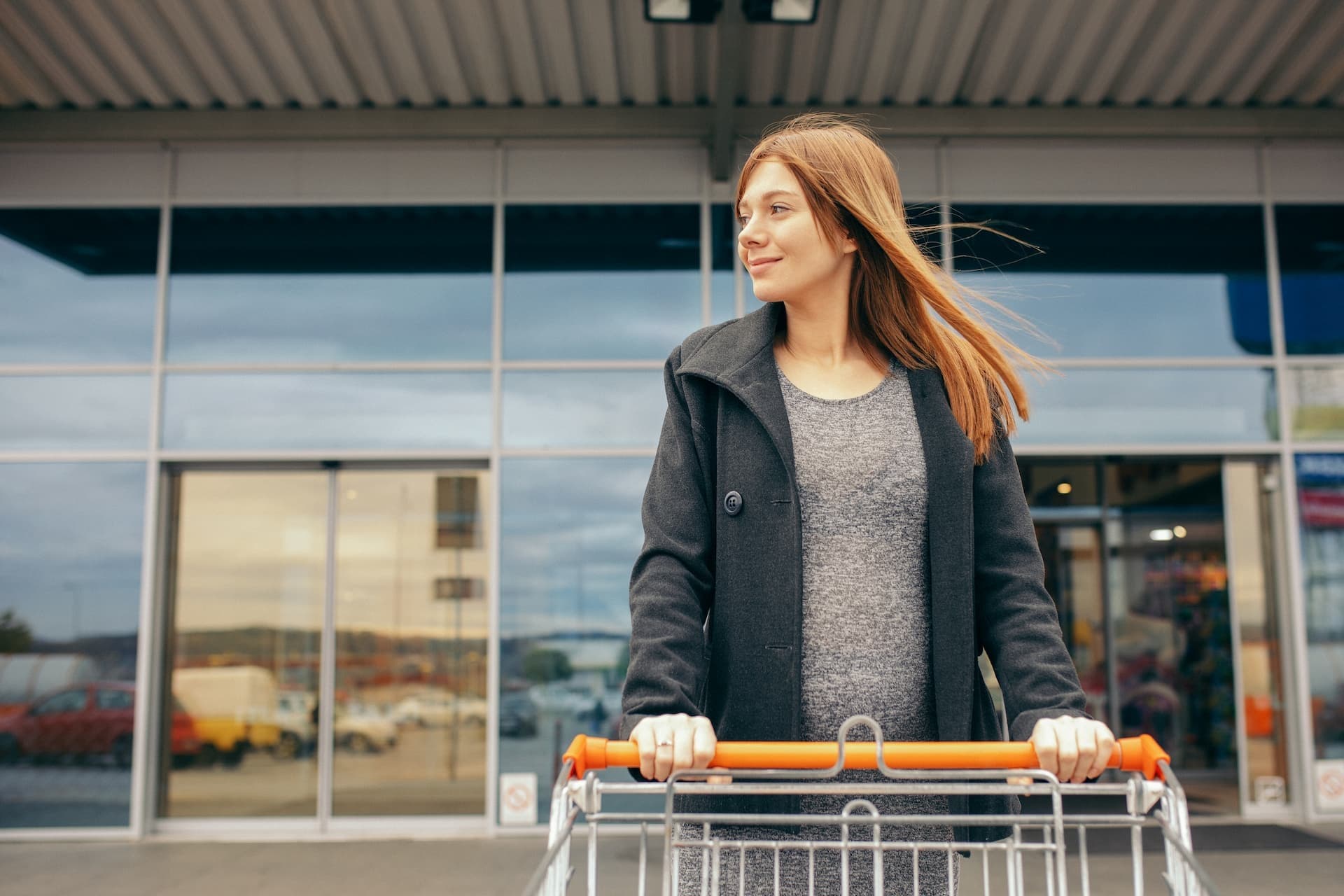 shopper with grocery cart existing mall with automatic doors
