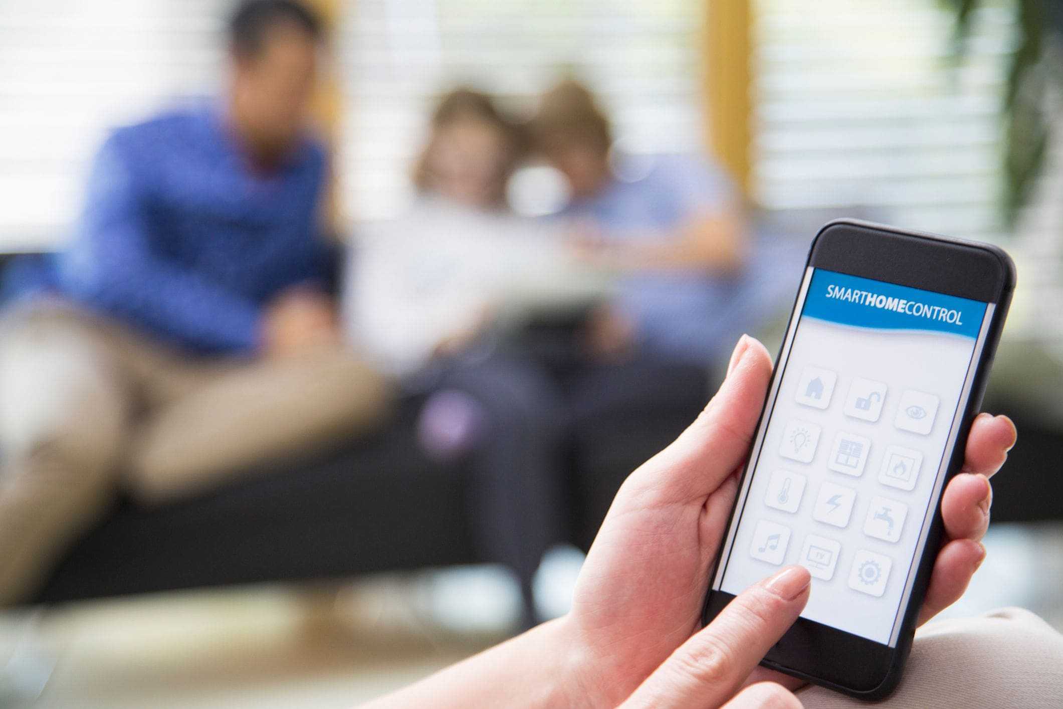 woman holding smartphone with home access controls set up woman holding smartphone with home access controls set up