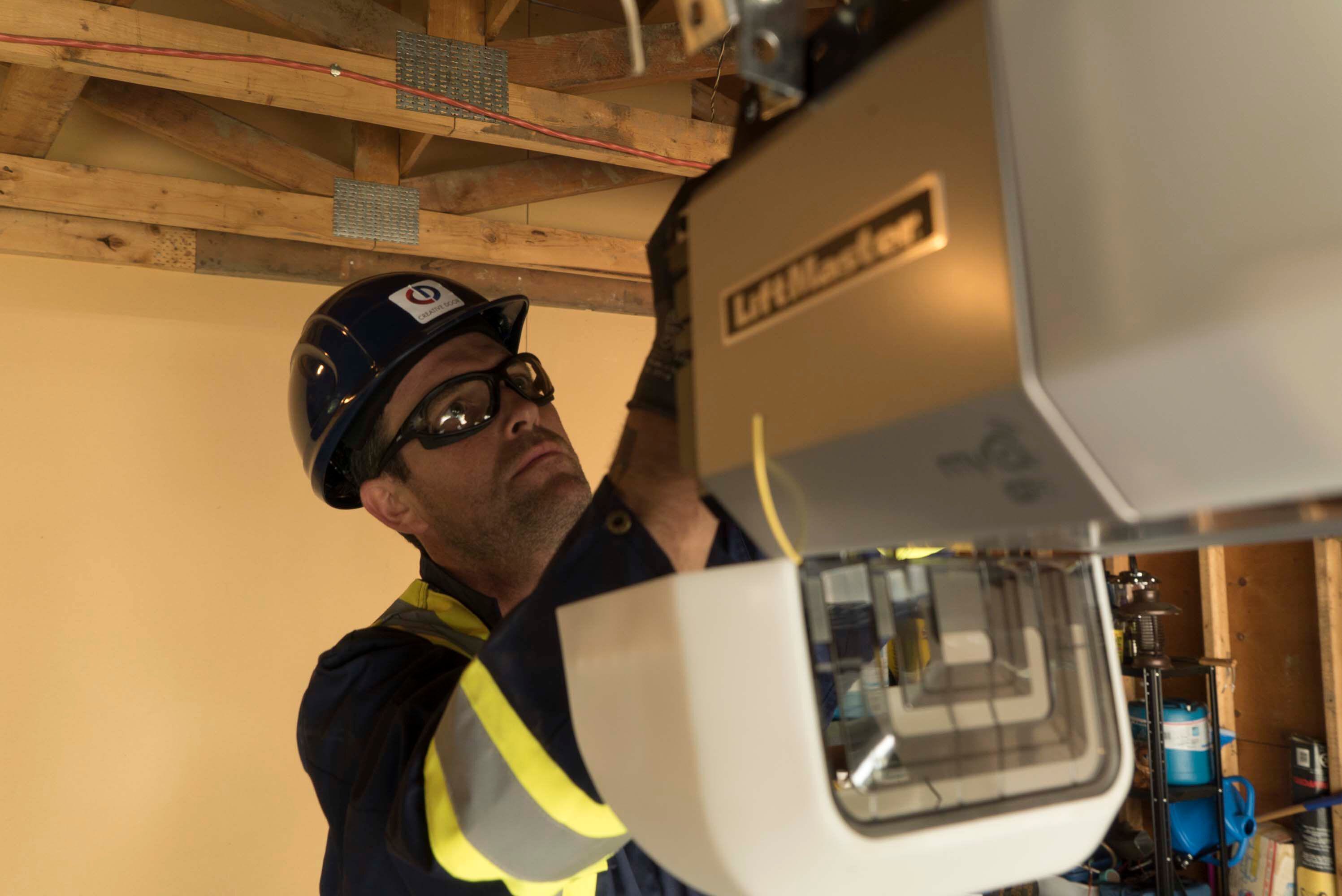Creative Door repair technician inspecting and repairing a liftmaster chain drive Creative Door repair technician inspecting and repairing a liftmaster chain drive