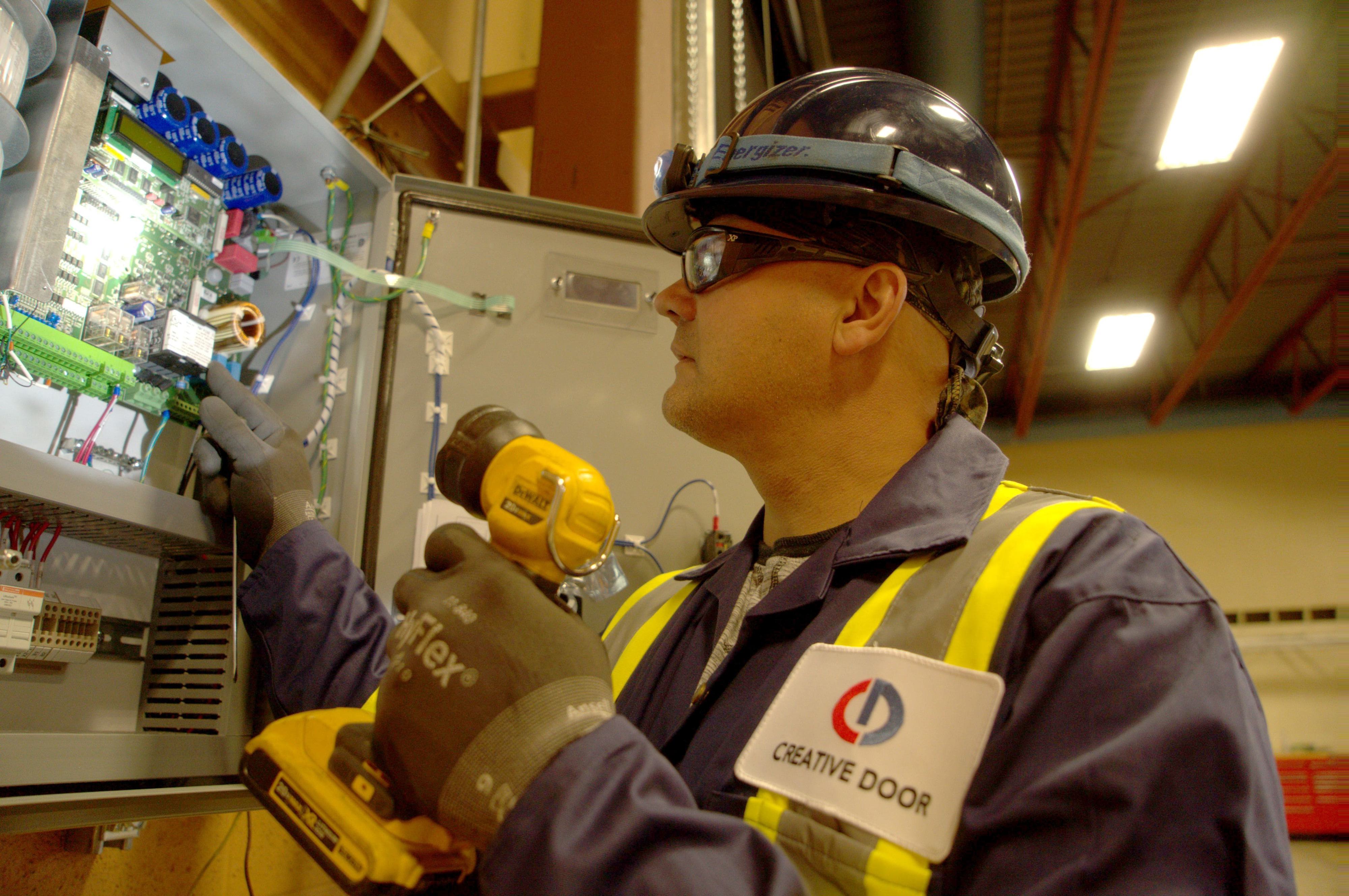 close up of technician calibrating commercial door operator