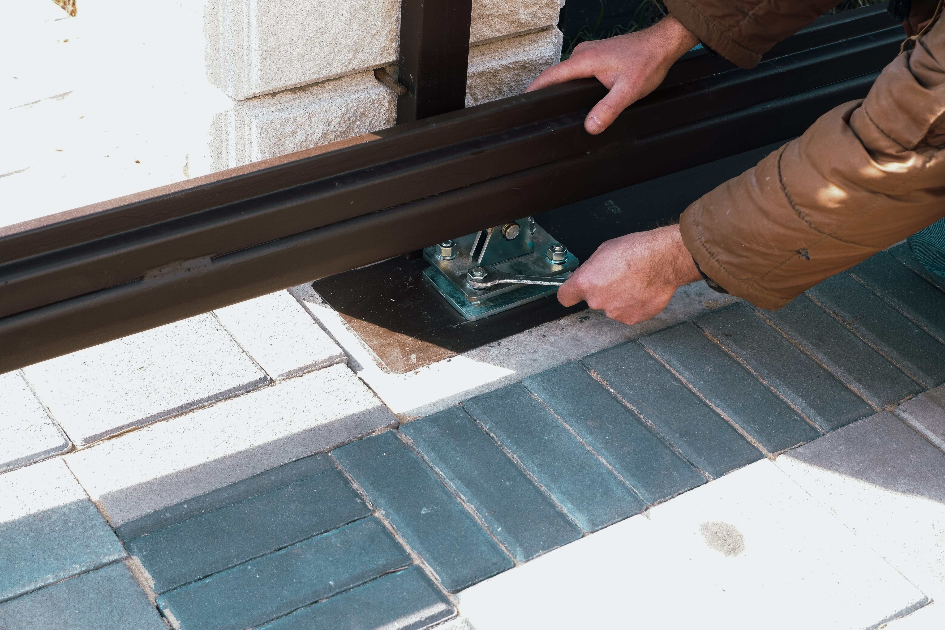 Technician adjusting sliding gate fitting