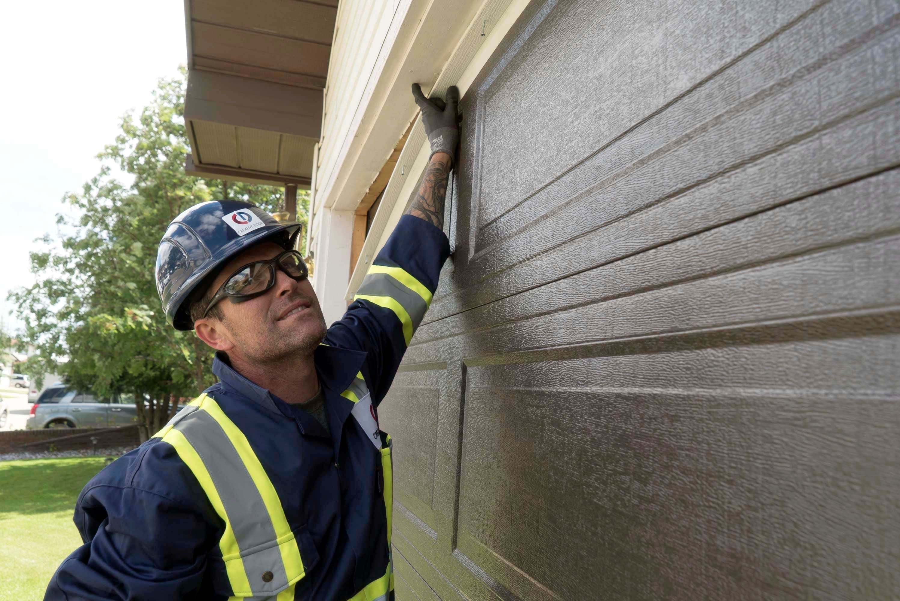 creative door technician performing a maintenance checklist on a residential garage door