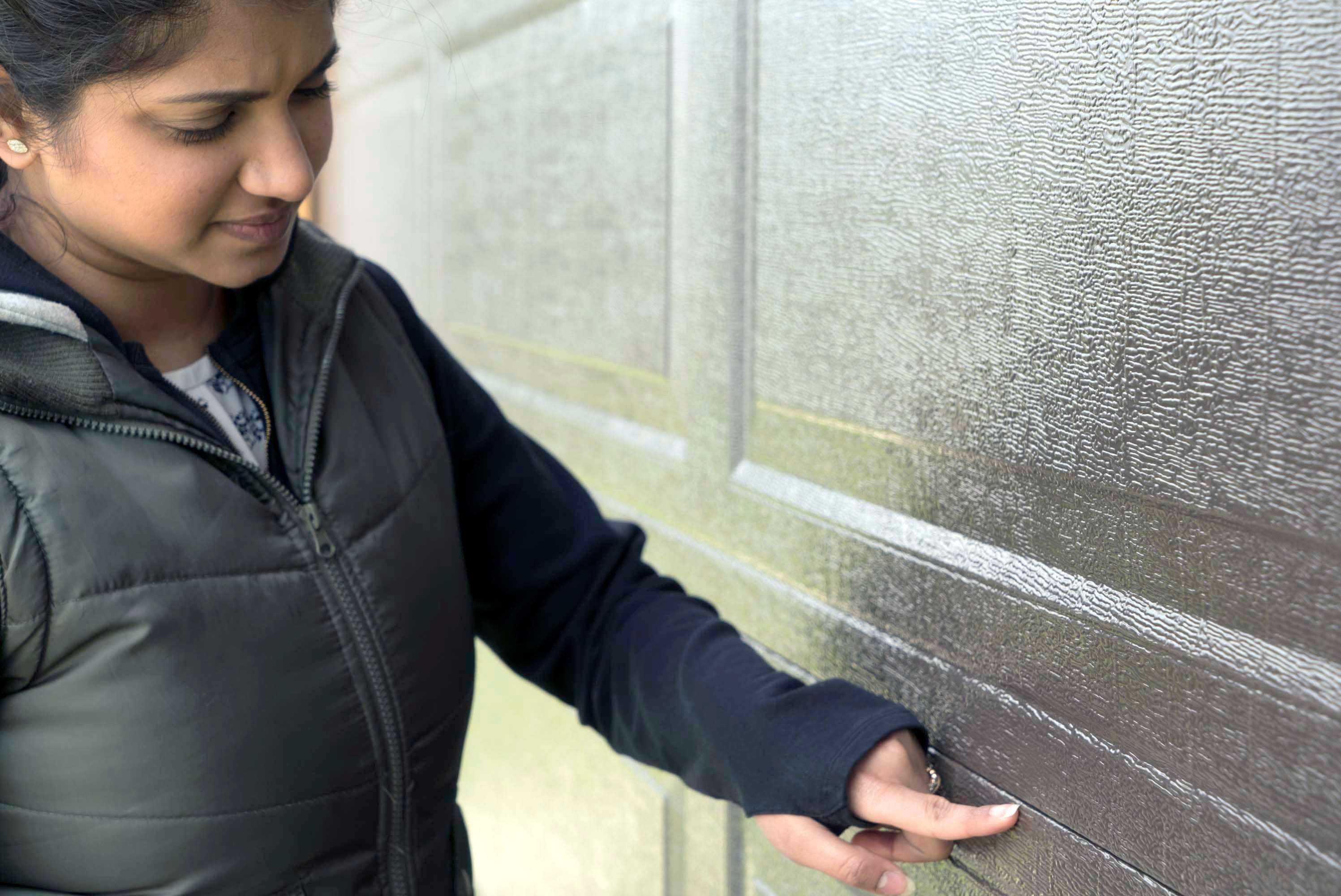 unhappy homeowner inspecting an old garage door