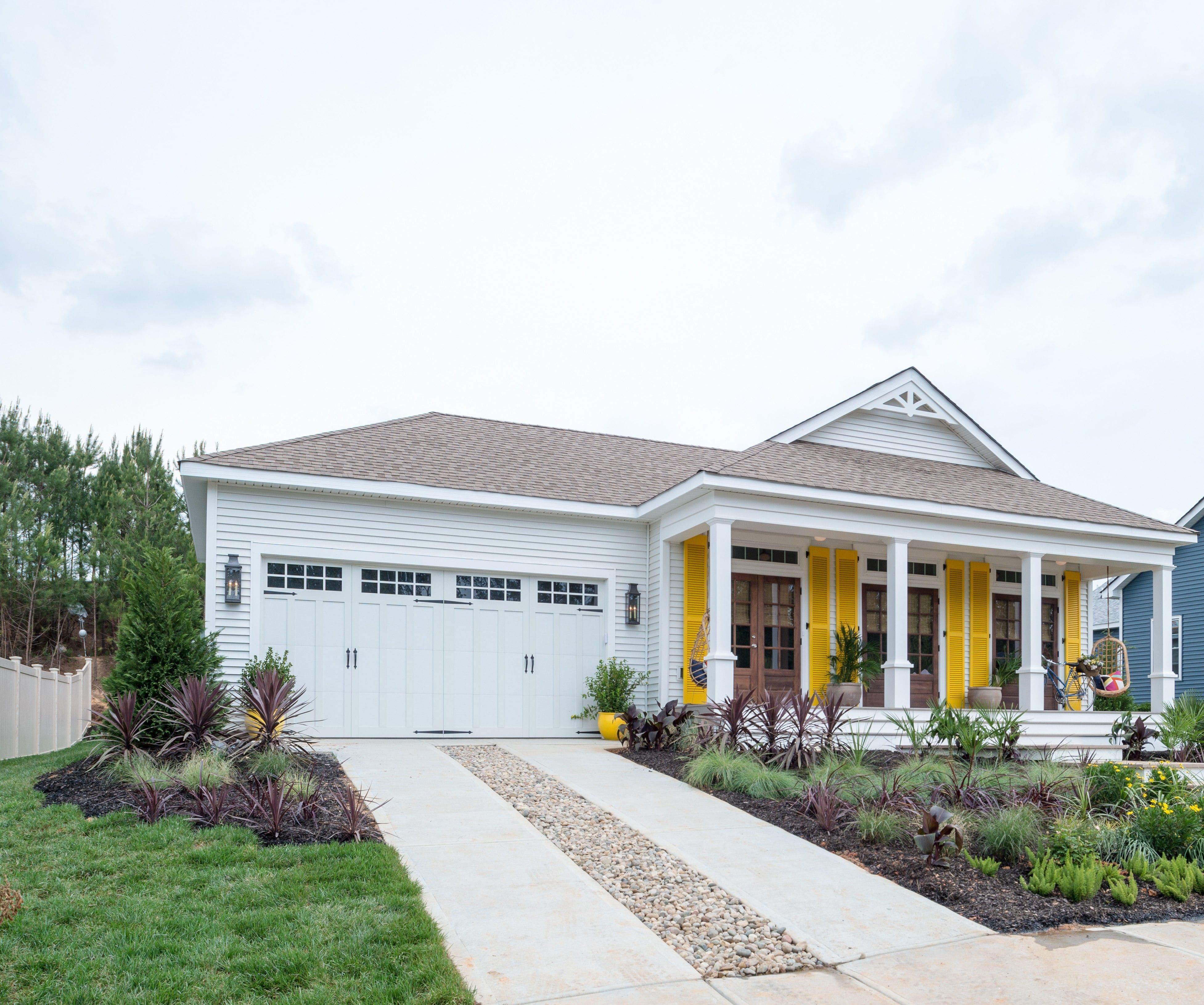 wayne dalton white garage door on house with yellow shutters and a beautiful summer lawn