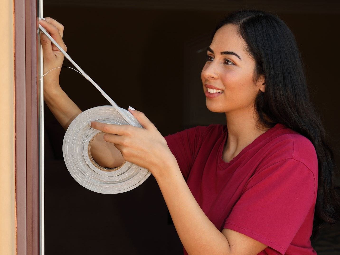 woman installing new weatherstip woman installing new weatherstip