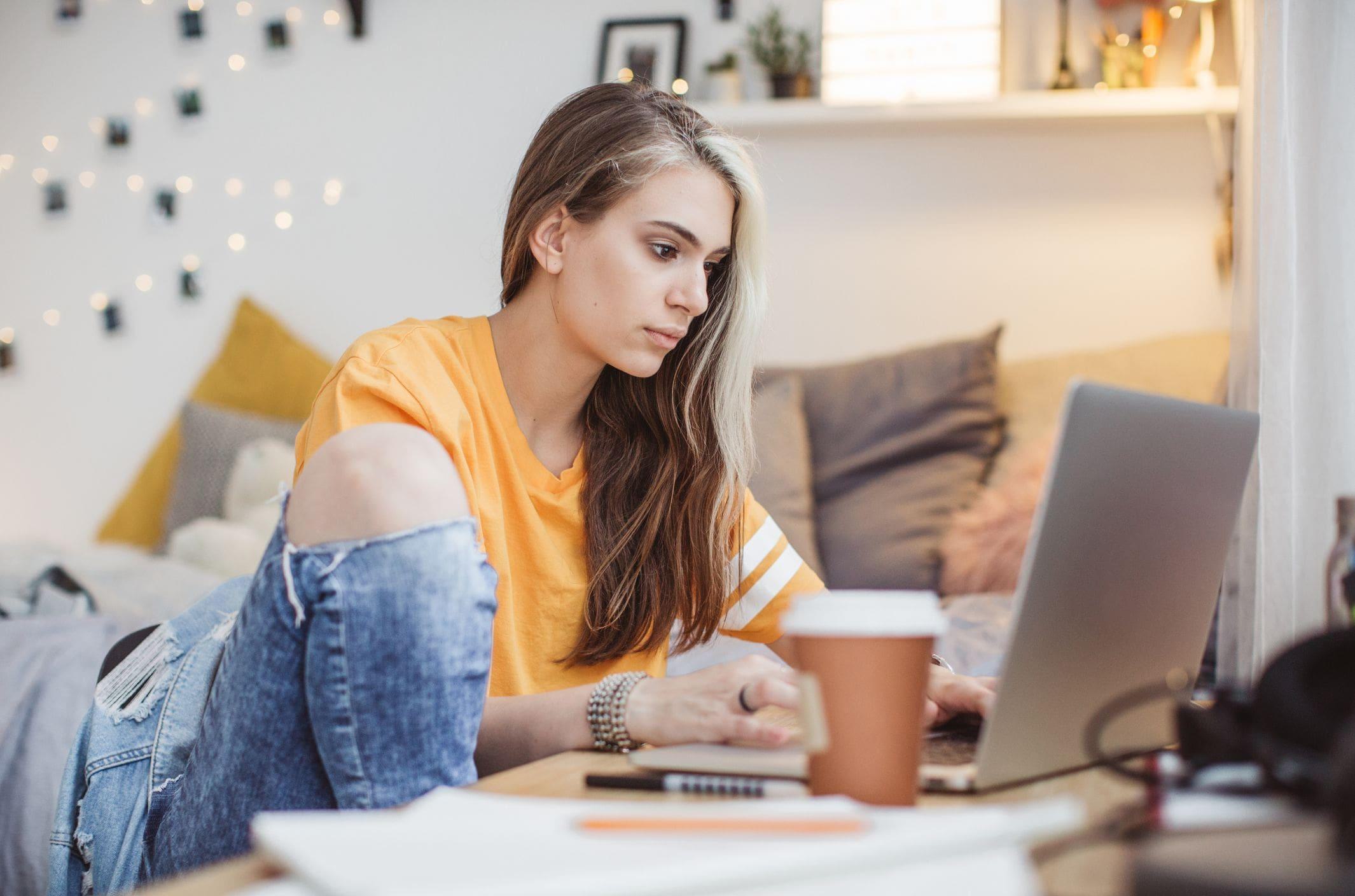 teenage girl working on homework in a bright converted garage study space with string lights teenage girl working on homework in a bright converted garage study space with string lights