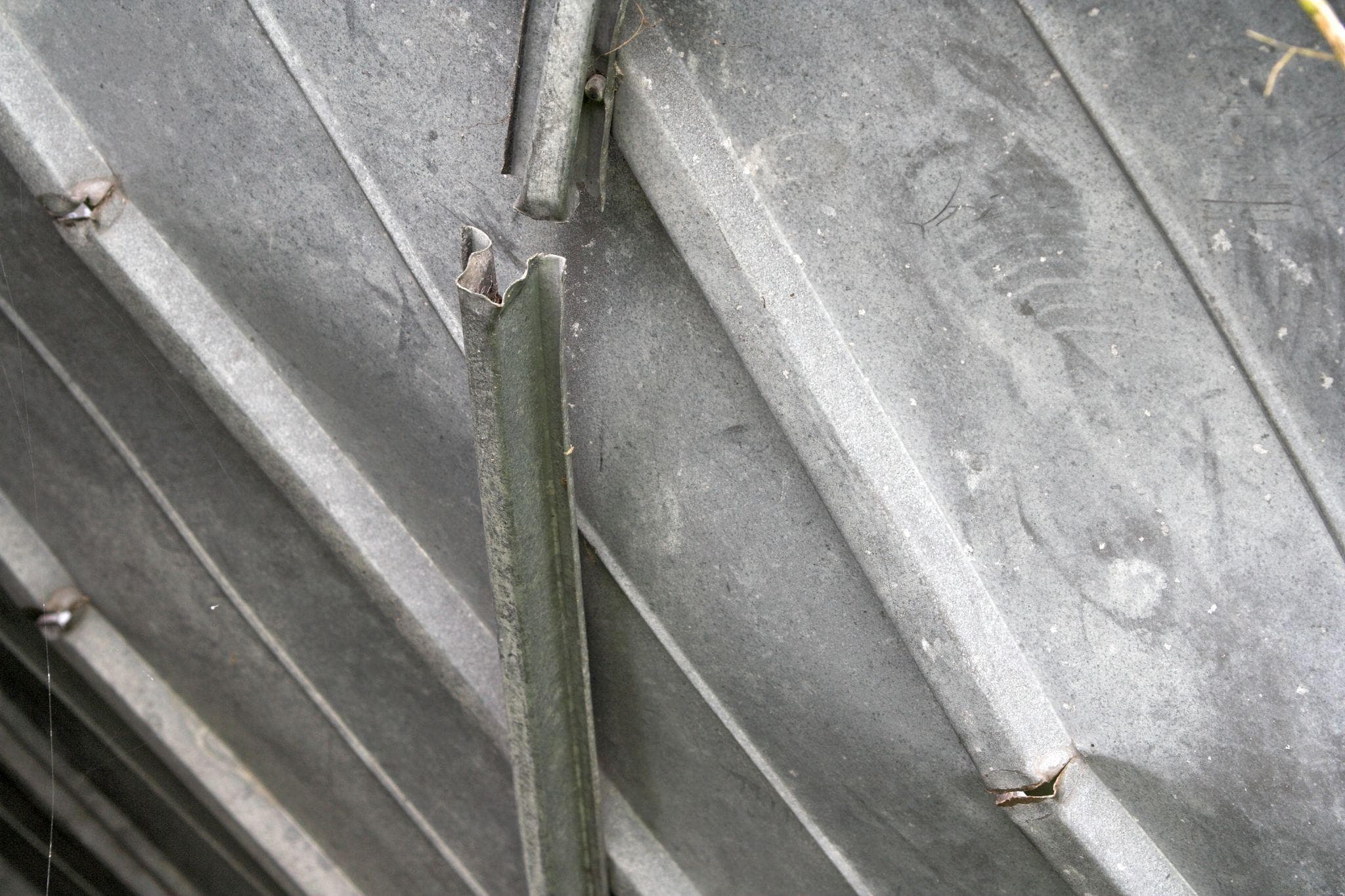 steel garage door closeup of bent and broken tracks